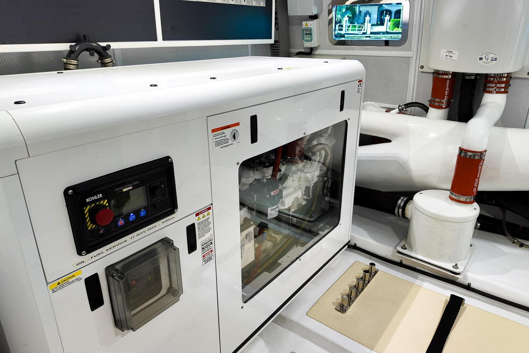 Engine room of 2022 Marlow Voyager Series yacht with Kohler generator and piping system.