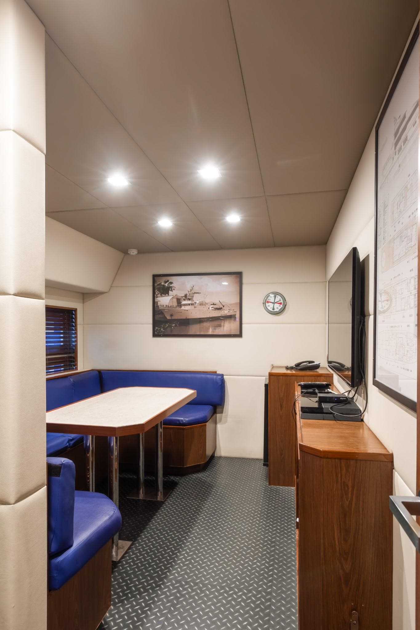 Cozy interior of a 1992 Custom Niigata with blue seating and wooden accents.