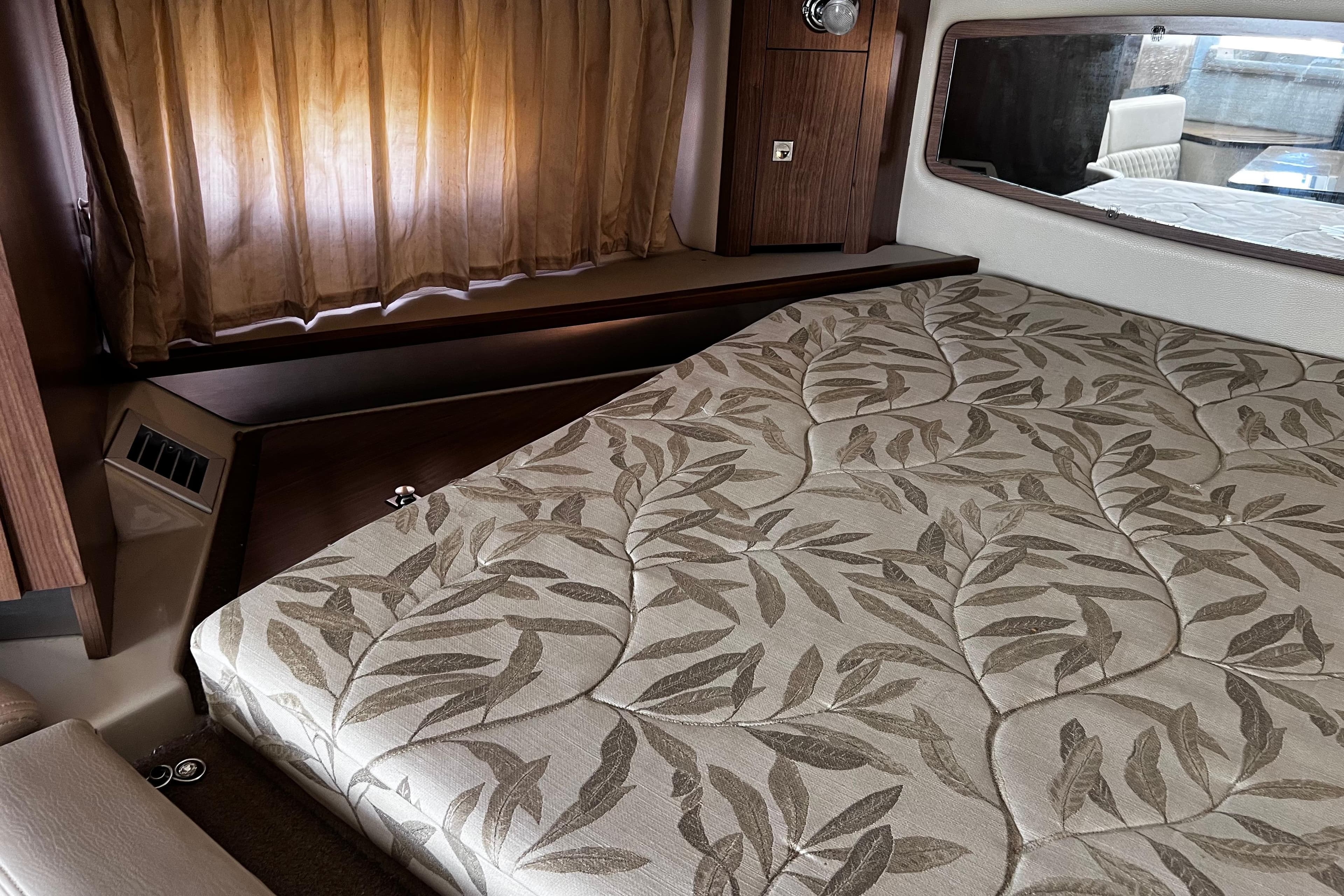 2011 Chaparral 310 Signature cabin with patterned bedding and wooden accents.