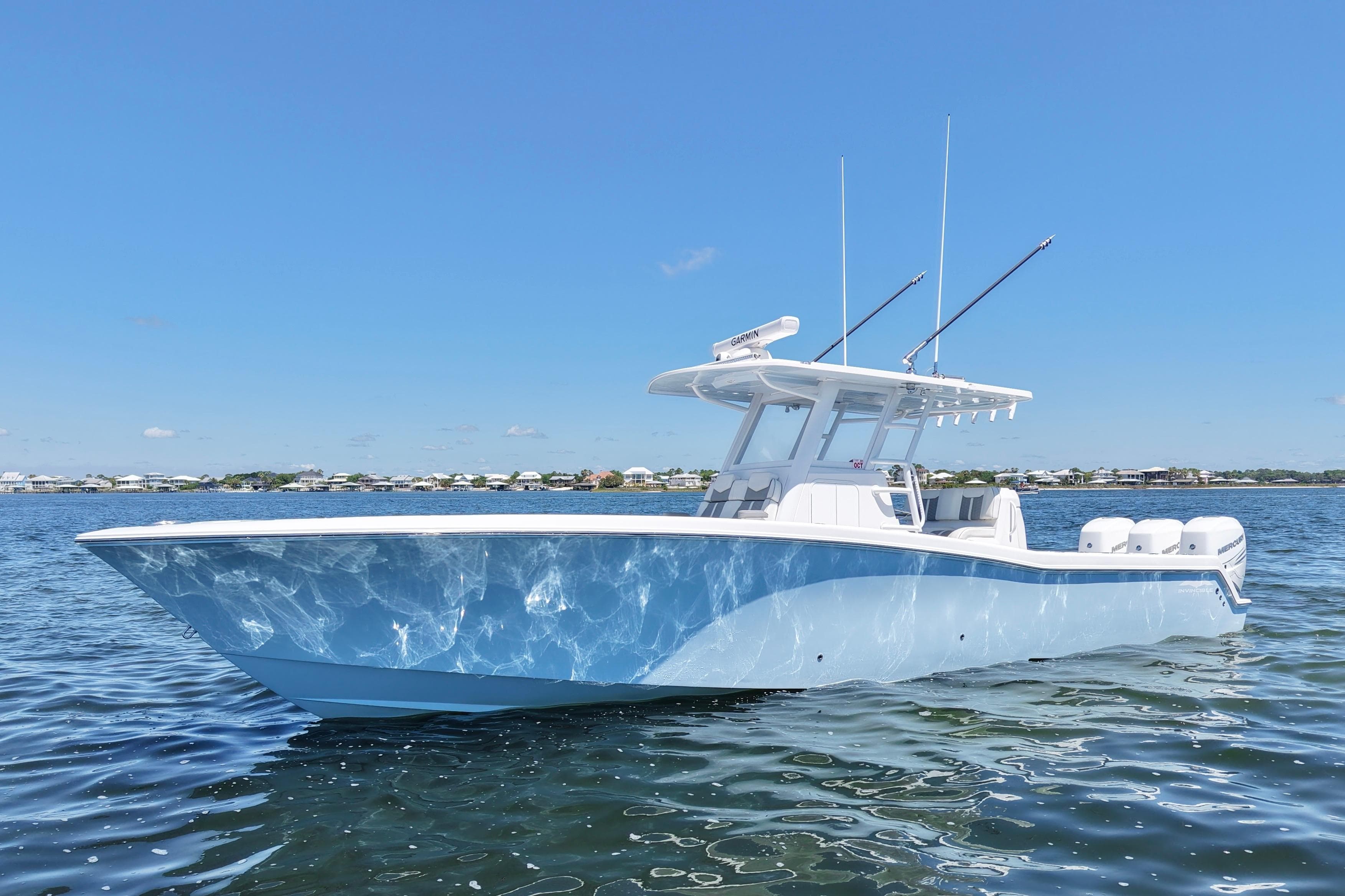 2023 Invincible 36 Open Fisherman boat on calm water under clear blue sky.