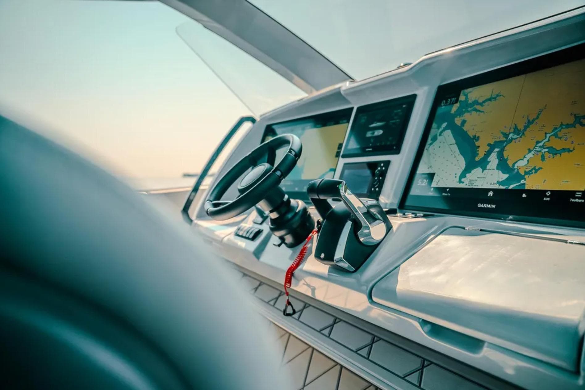 2026 Deep Impact 499 Sport boat dashboard with steering wheel and navigation screens.