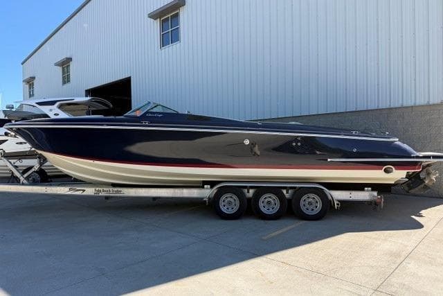 2022 Chris Craft 34 Launch Heritage boat on a trailer outside a warehouse.