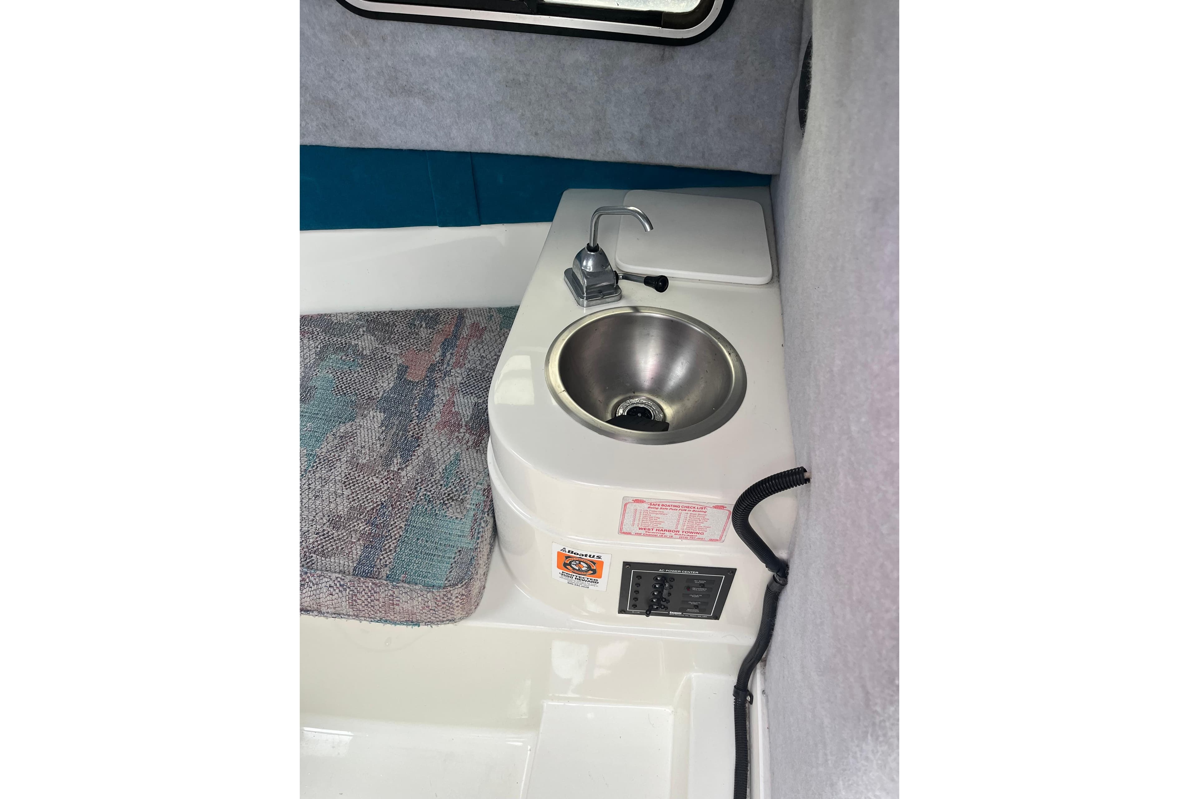 Interior of 1995 Celebrity 2500 Fish Hawk boat featuring a compact sink and control panel.