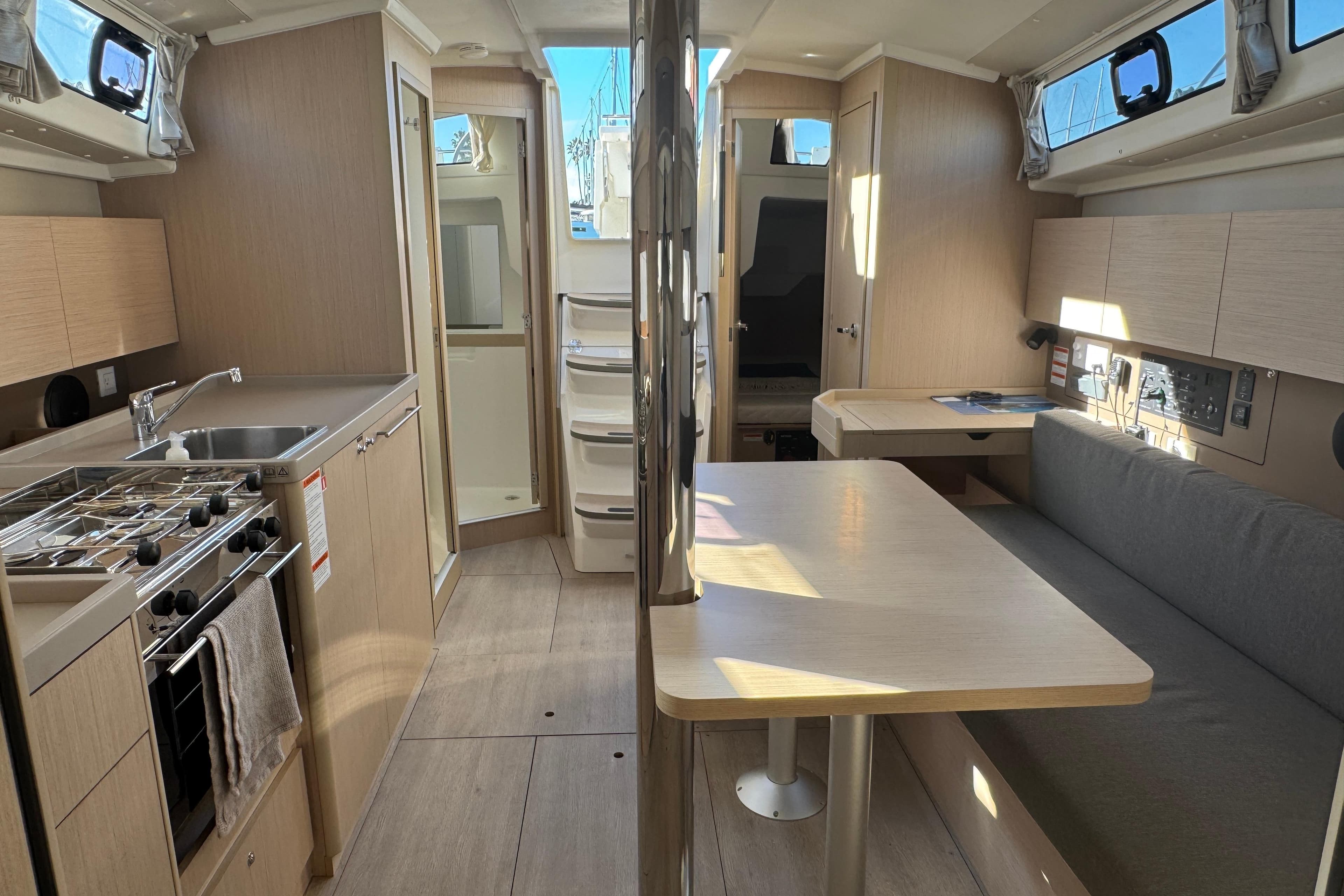 Interior of 2023 Beneteau Oceanis 38.1 yacht, featuring modern kitchen and dining area.