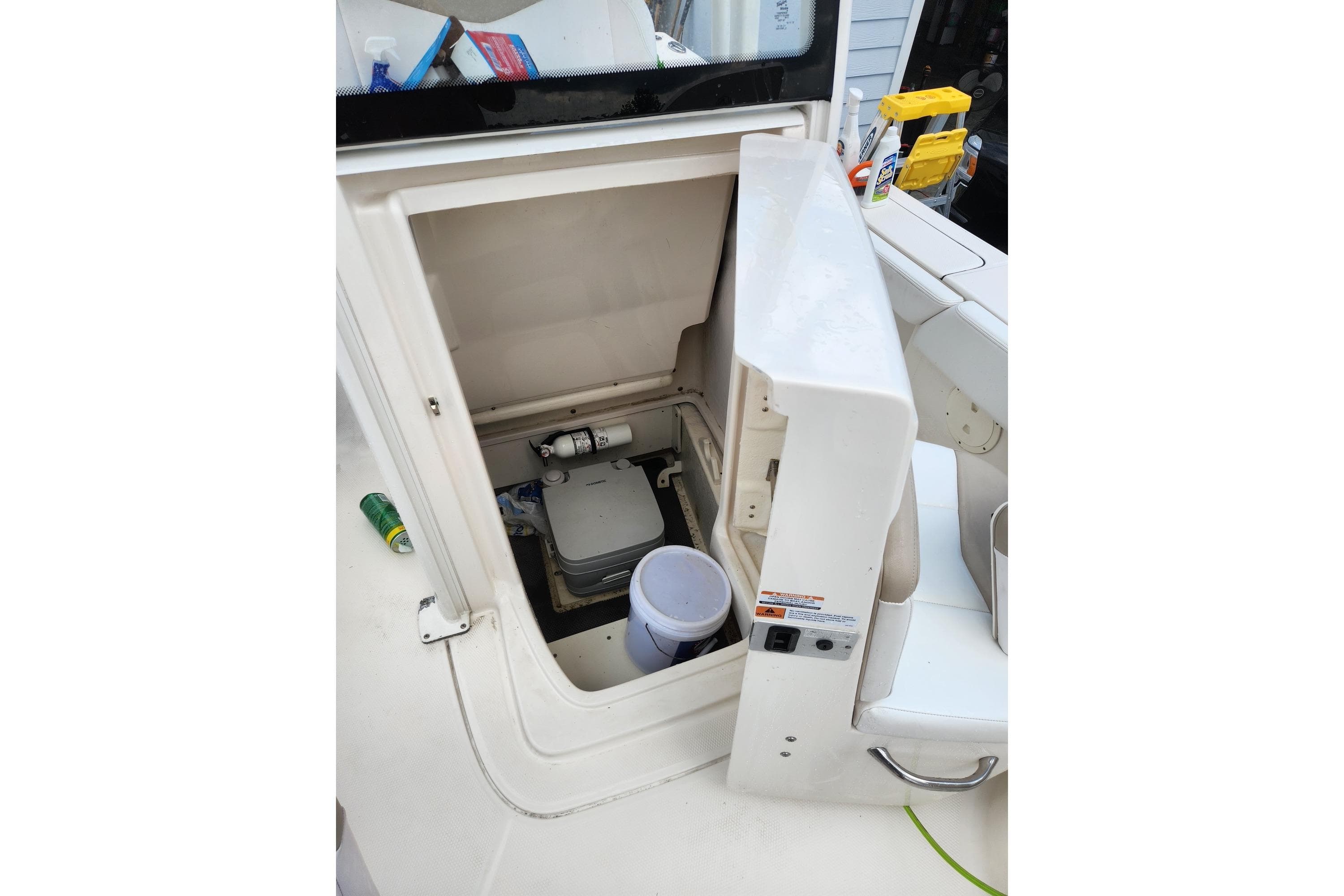 2020 Robalo 246 Cayman boat storage compartment with open hatch and cleaning supplies.