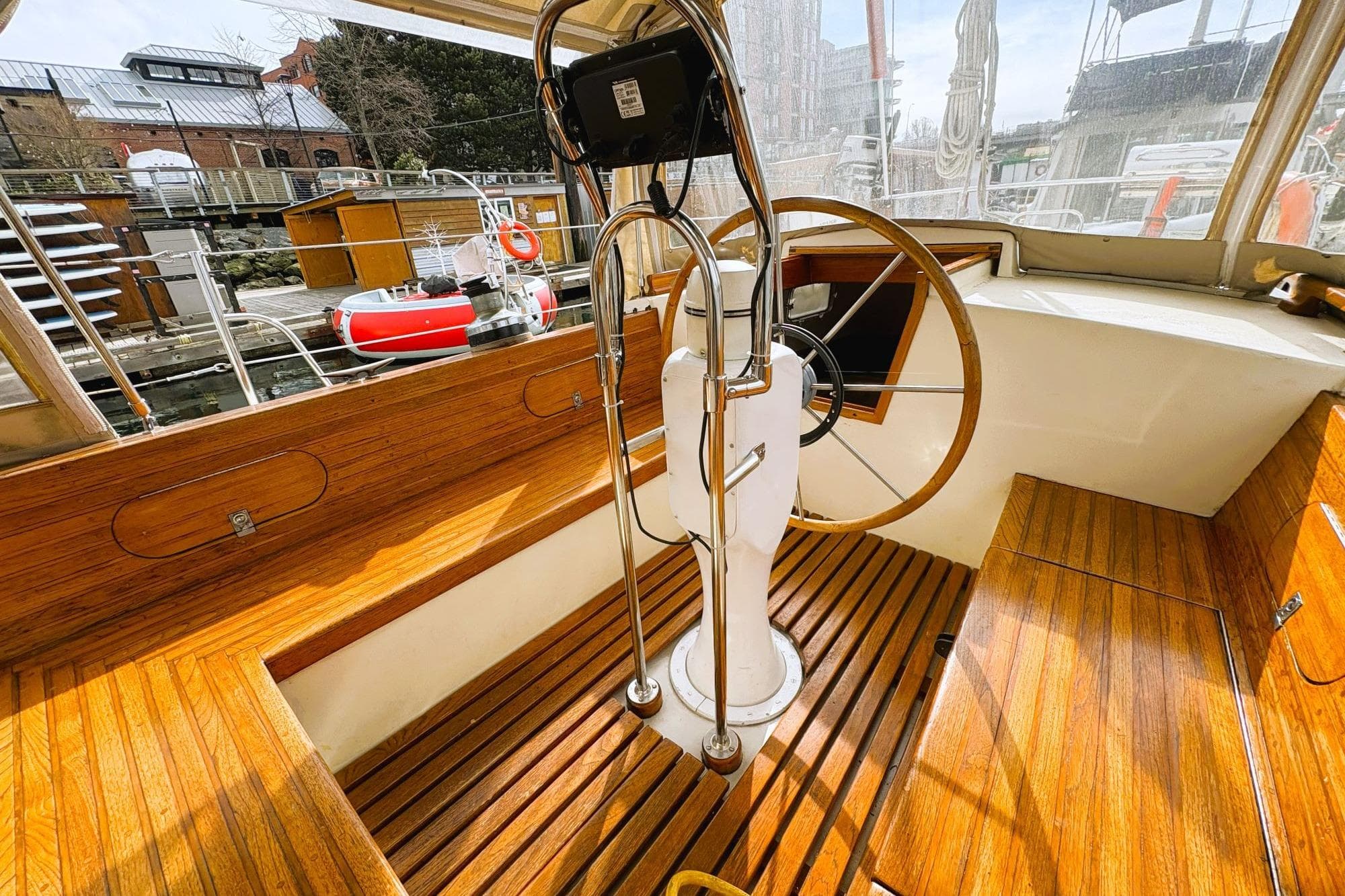 1980 Discovery 42 yacht cockpit with wooden flooring and steering wheel.