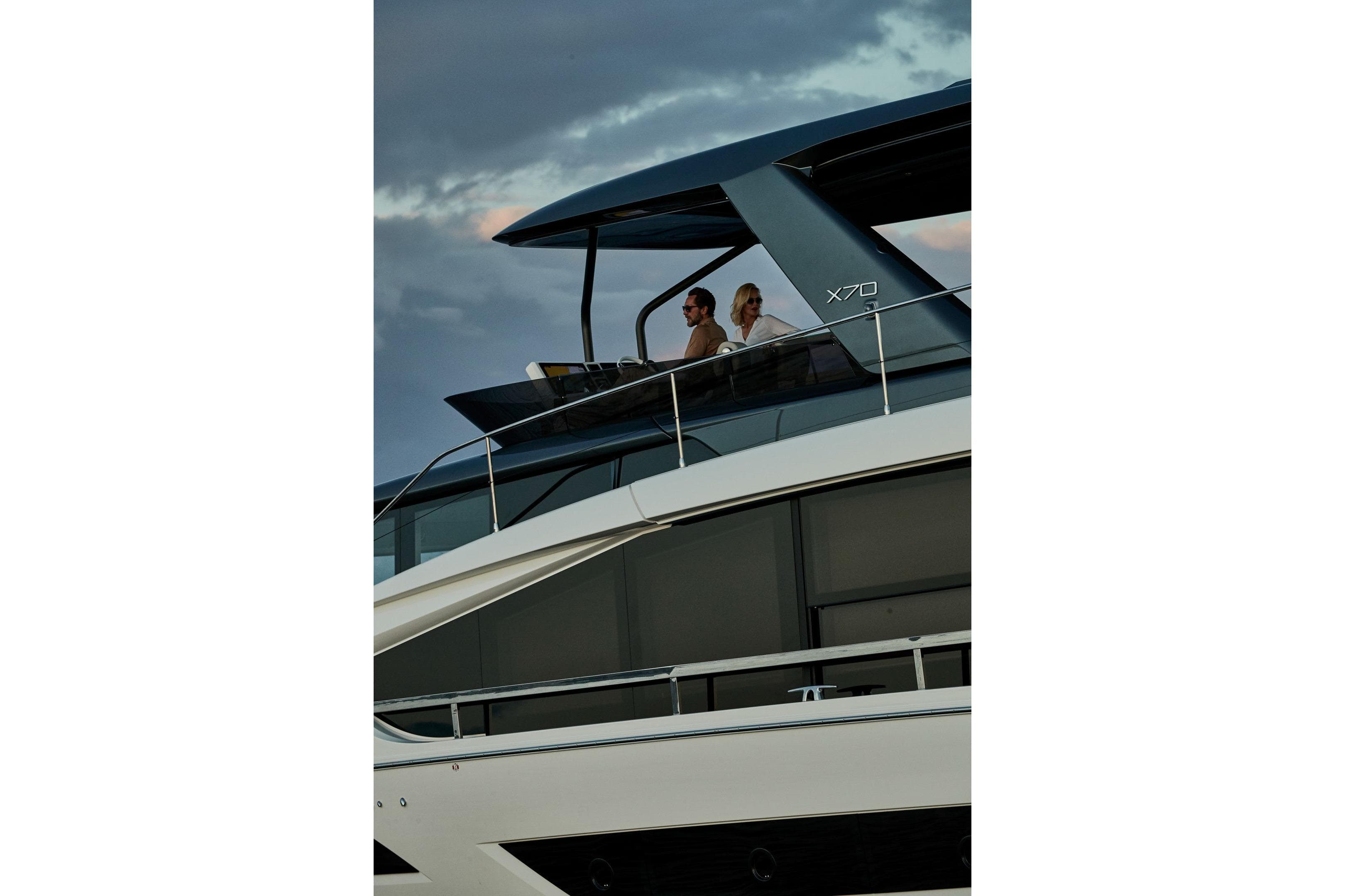 Luxury 2026 Prestige X70 yacht with passengers enjoying the view at sunset.
