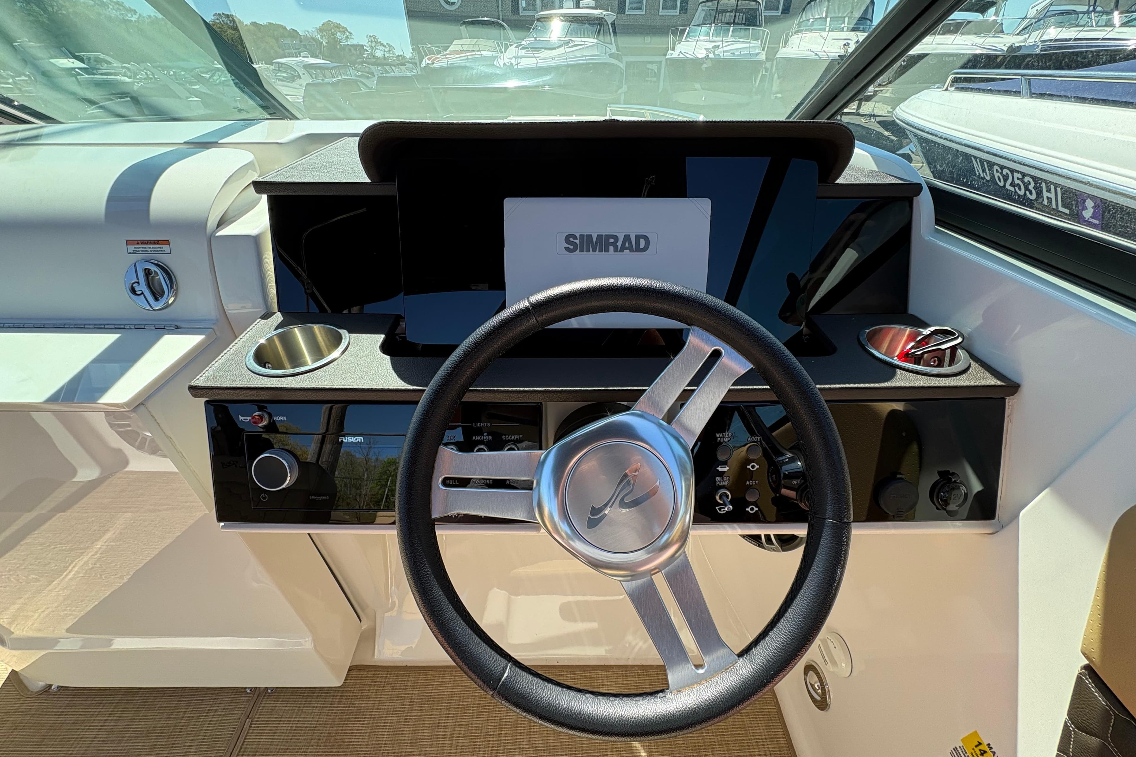 2024 Sea Ray SDX 250 Outboard helm with steering wheel and Simrad display.