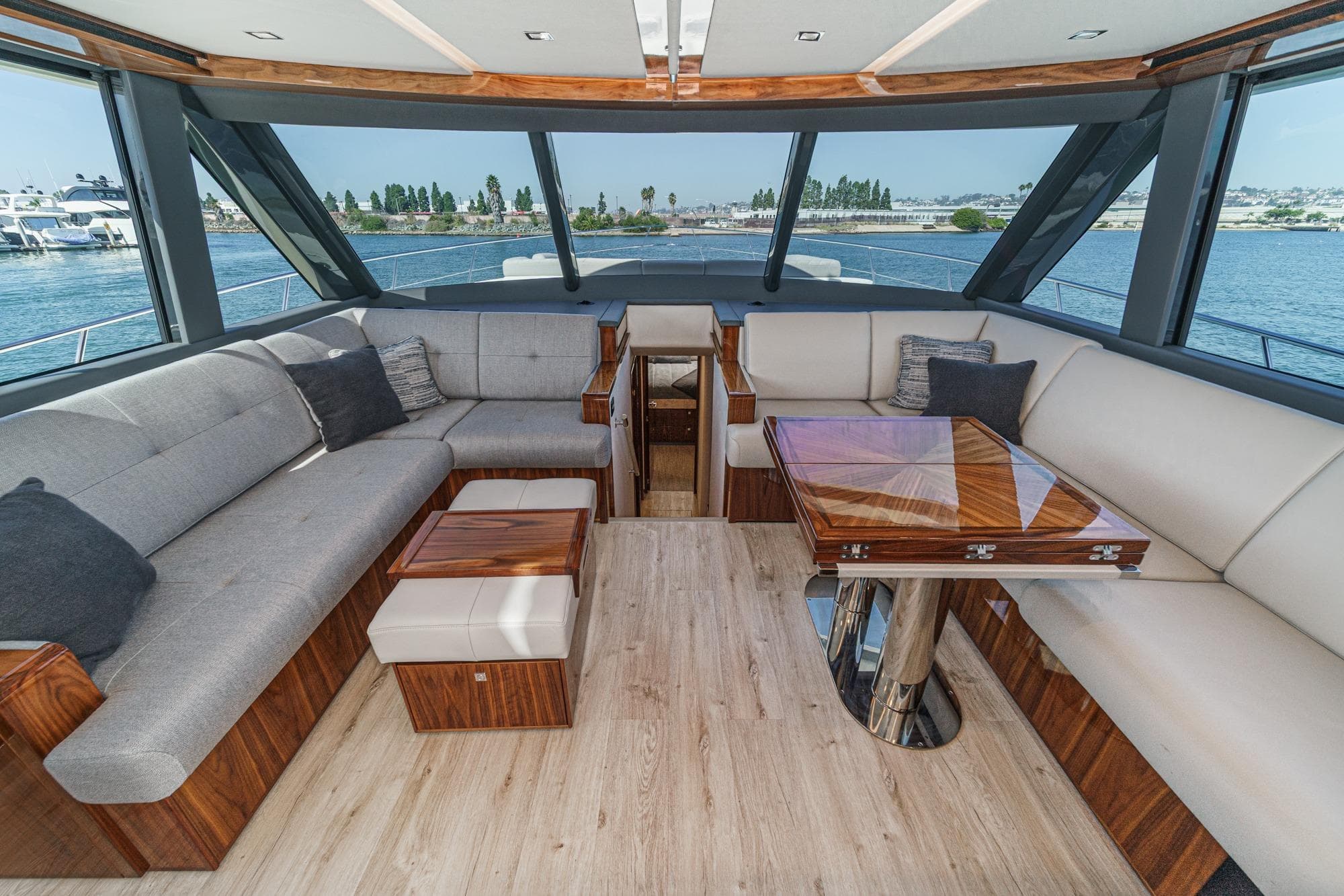 Luxurious interior of 2023 Riviera 64 Sports Motor Yacht with elegant seating and wooden table.