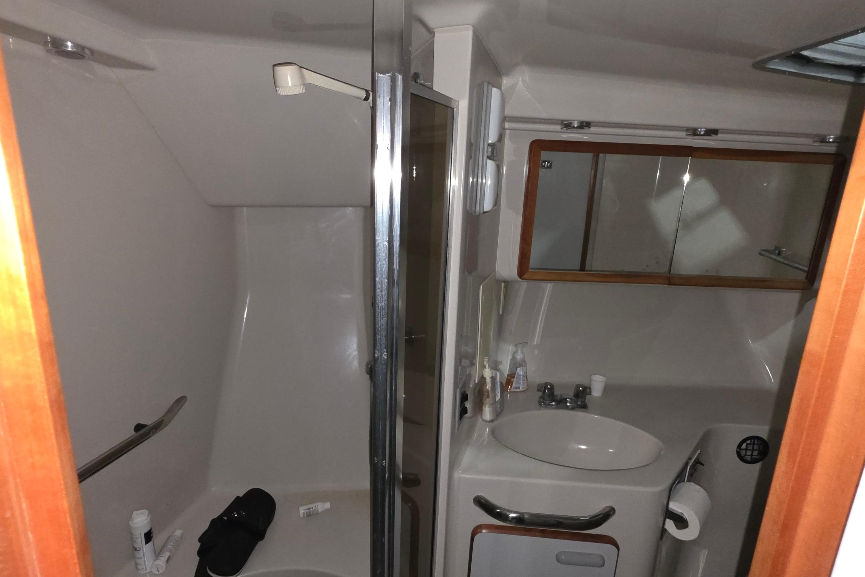 Bathroom interior of 1989 Sea Ray 420 Sundancer yacht, featuring sink and shower.