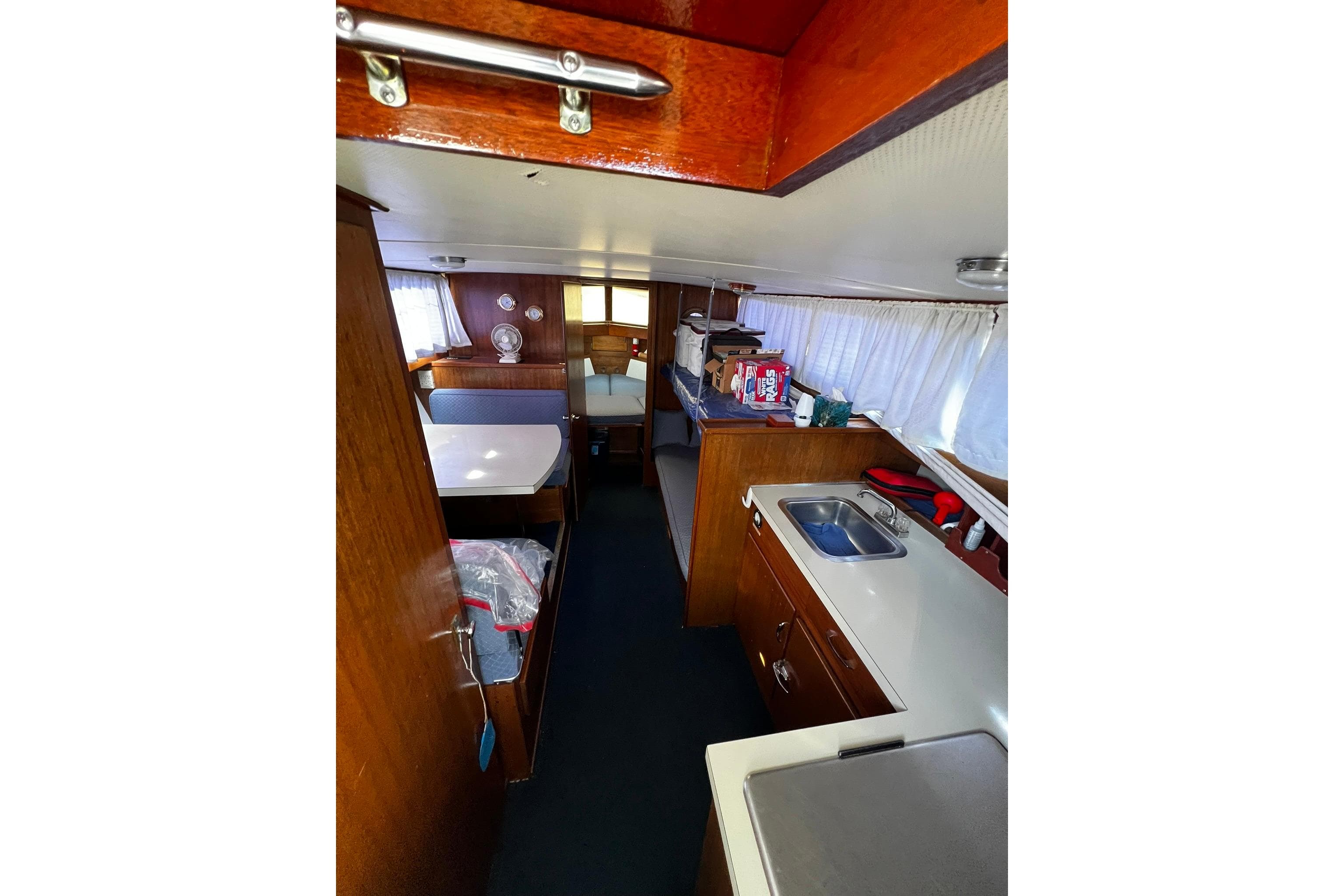 Interior of a 1967 Chris-Craft 31 Commander boat, featuring a compact kitchen and dining area.