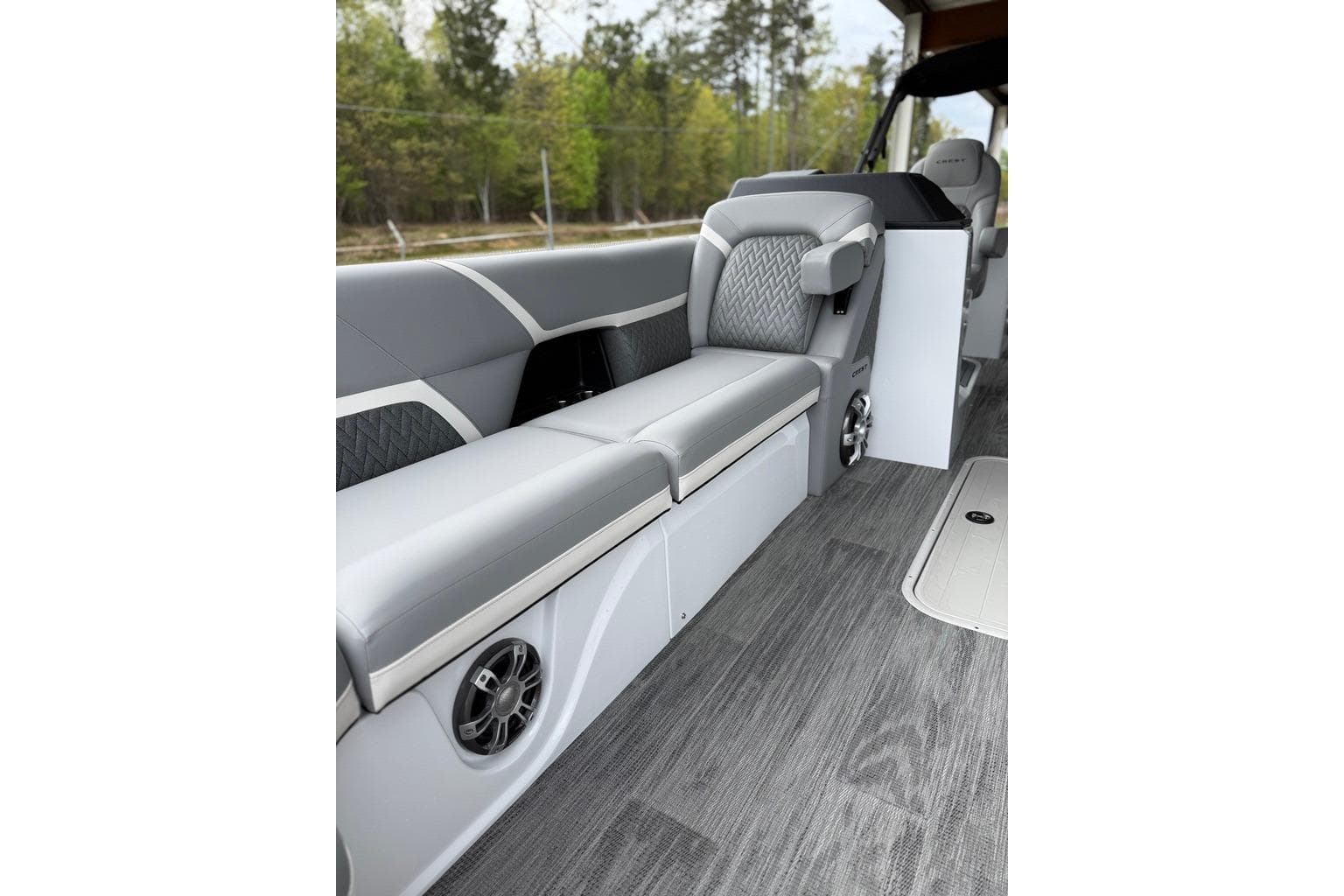 2026 Crest Caribbean 250 SLRC boat interior with gray seating and wood-style flooring.