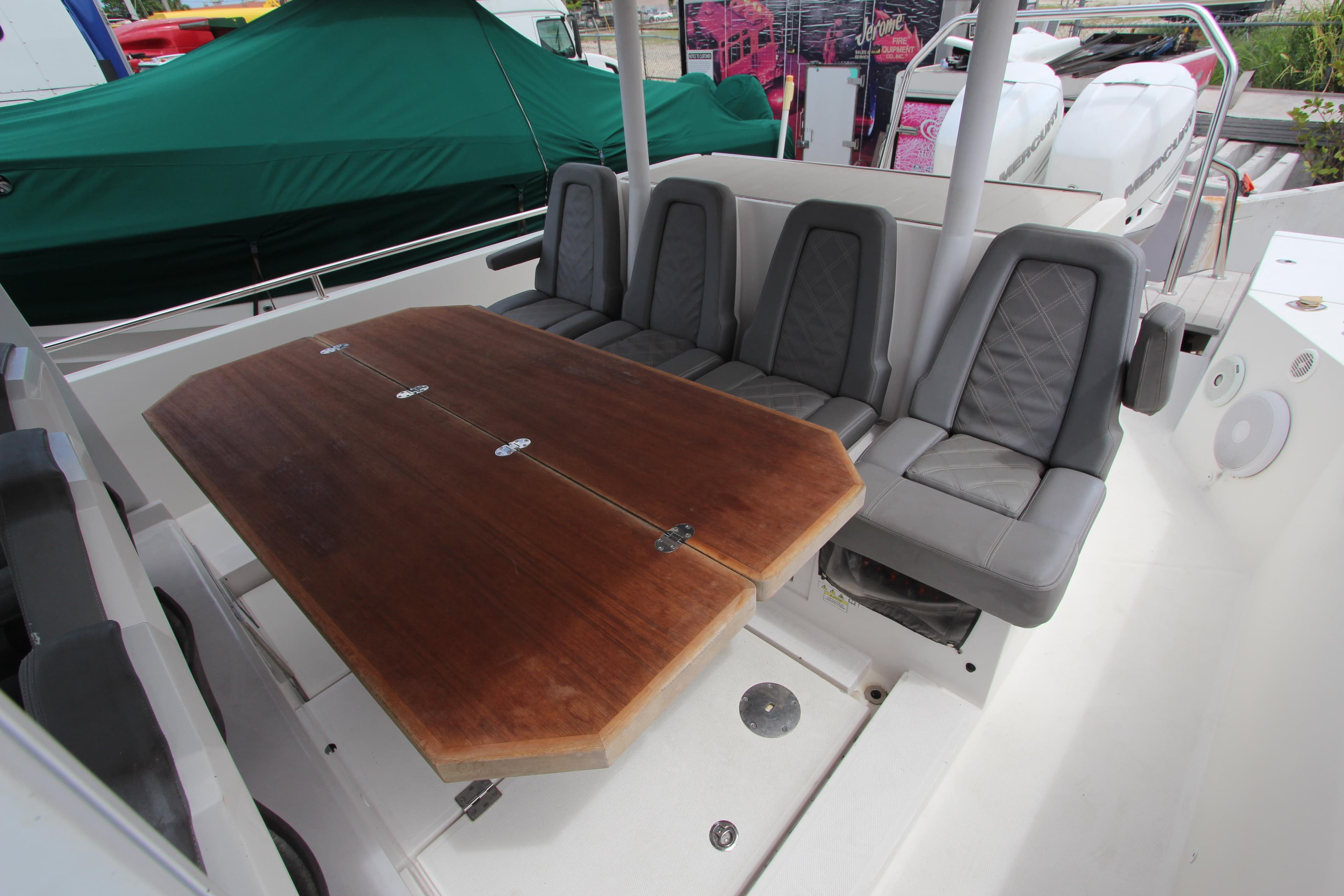 2018 Axopar 37 Sun-Top boat interior with wooden table and cushioned seating.
