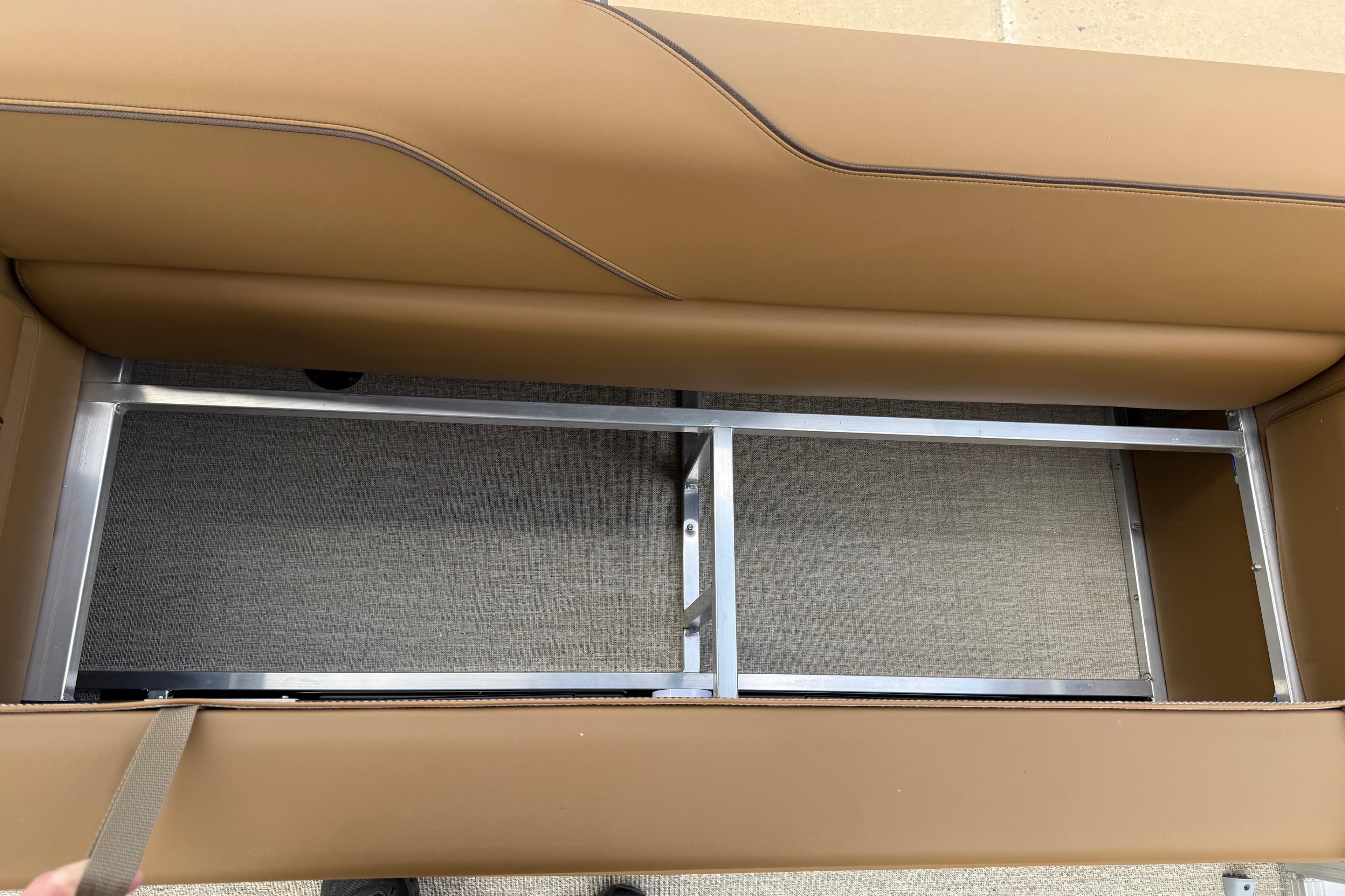 2026 Avalon VENTURE QUAD LOUNGE seat storage compartment with metal frame and tan upholstery.