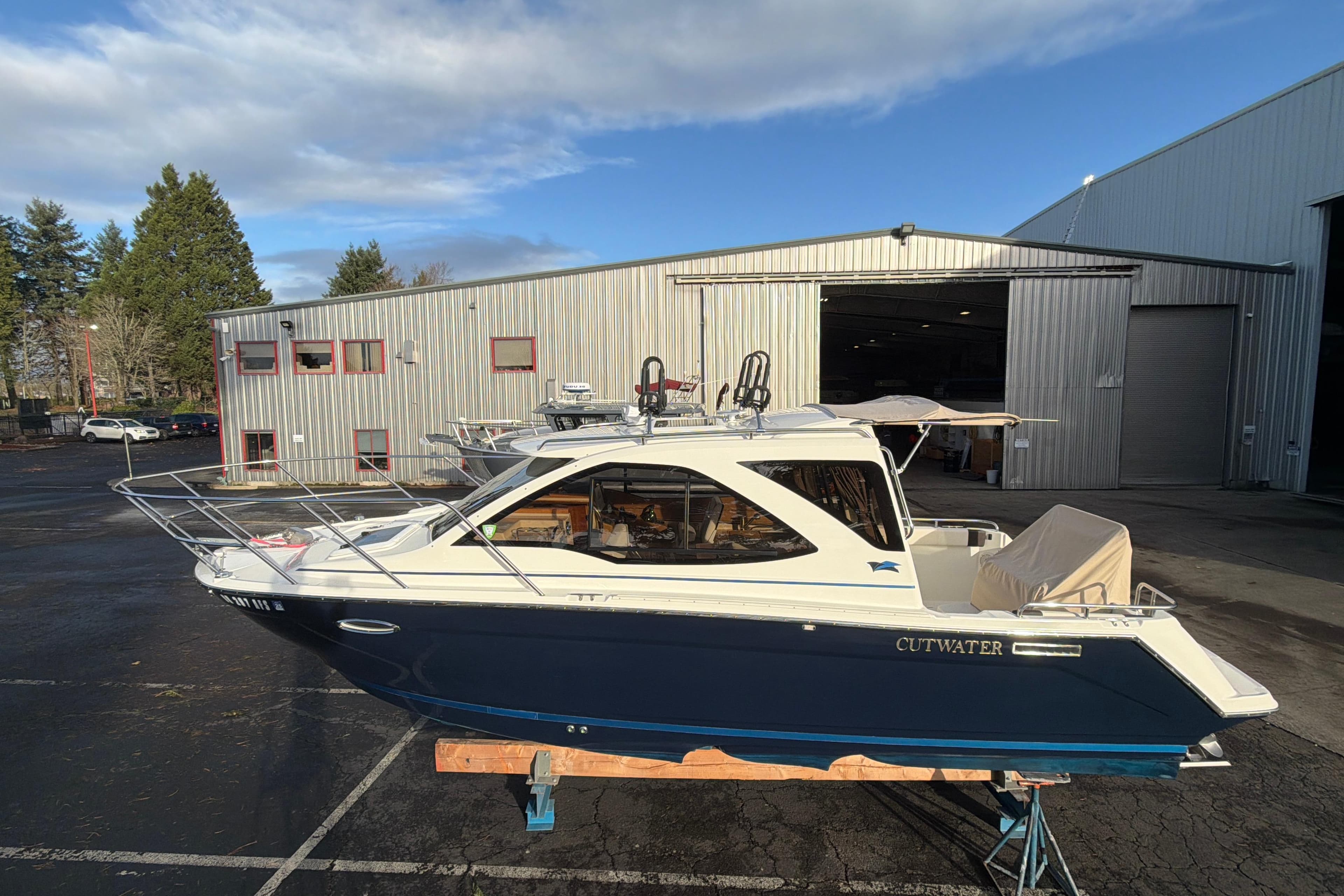 2016 Cutwater C-242 Coupe boat on a stand outside a warehouse.