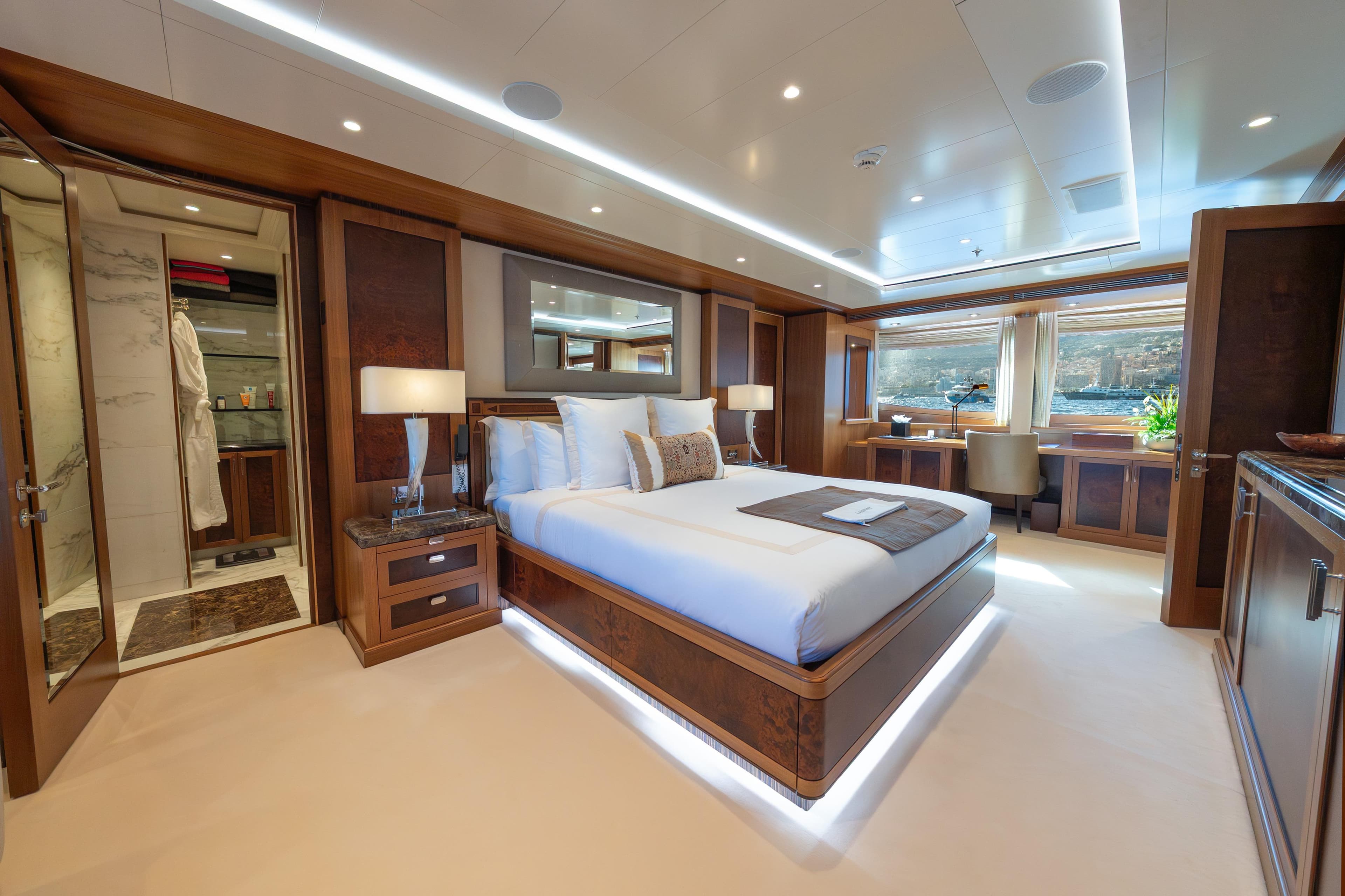 Luxurious bedroom on 2009 Timmerman Expedition Tri-Deck yacht with elegant wood finishes.