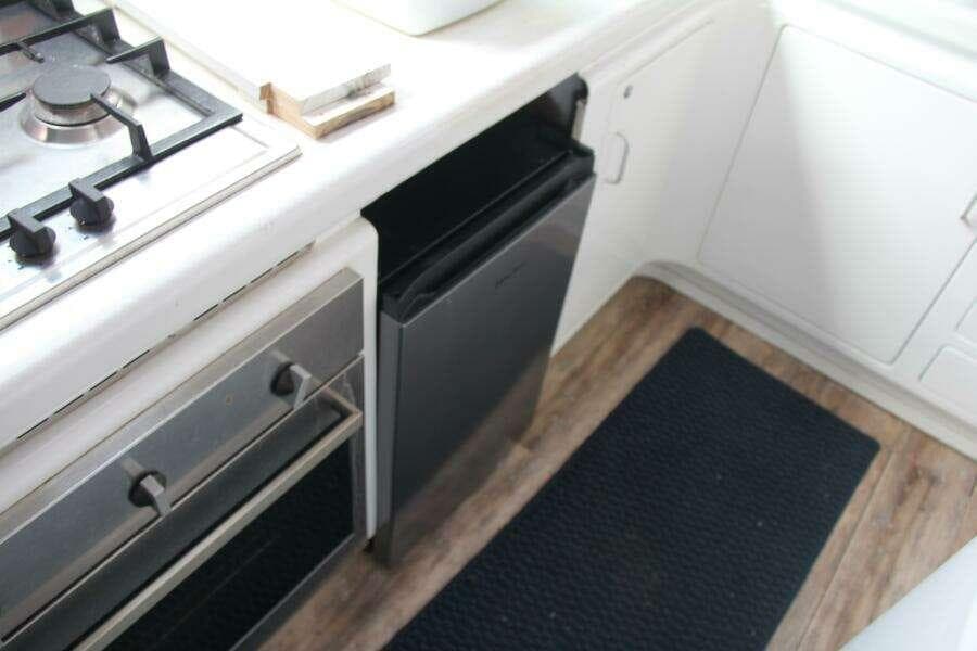 Compact kitchen area in a 1995 Voyage Yachts Mayotte, featuring stove and fridge.