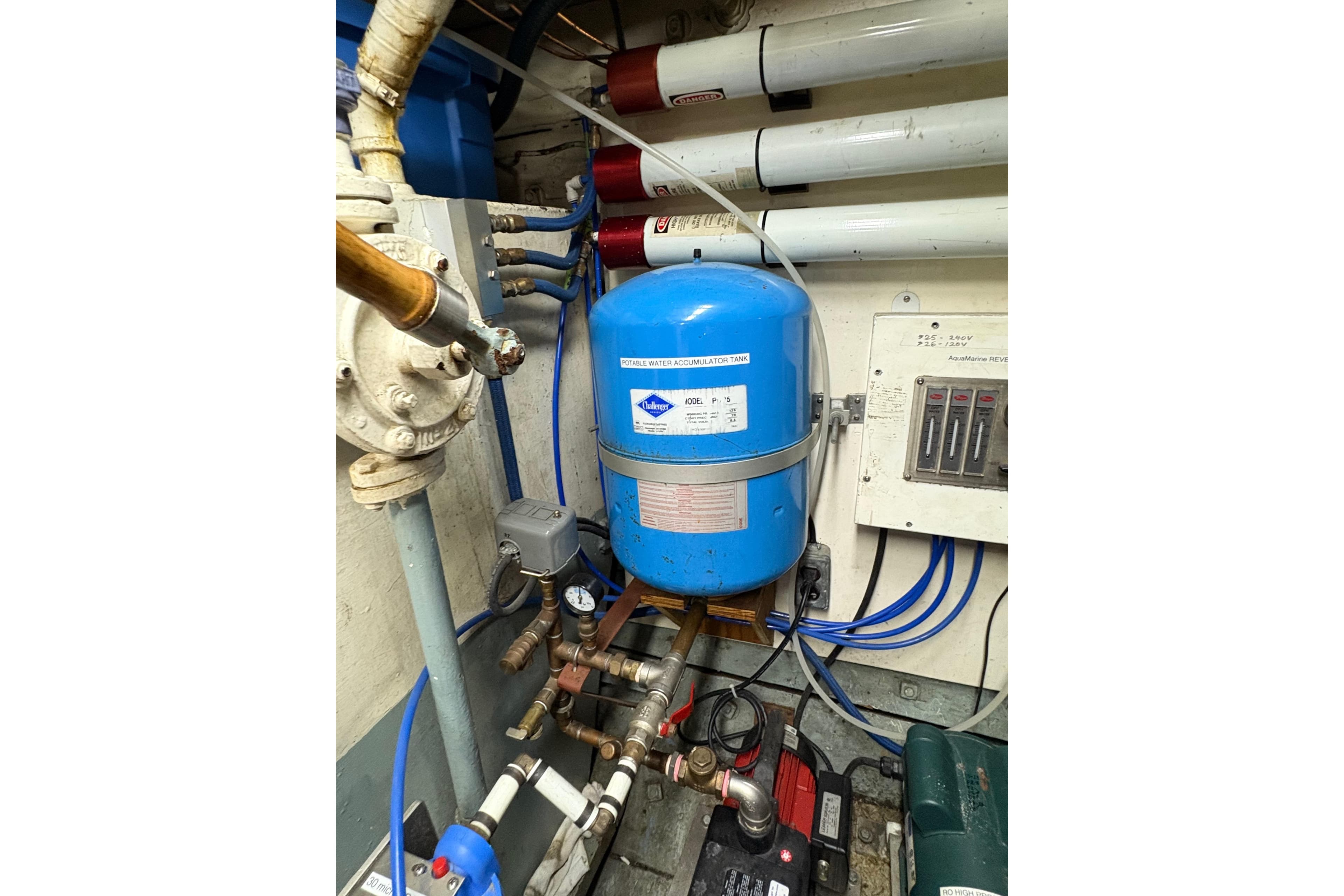 Engine room of 1941 McKenzie Tug with blue accumulator tank and piping system.