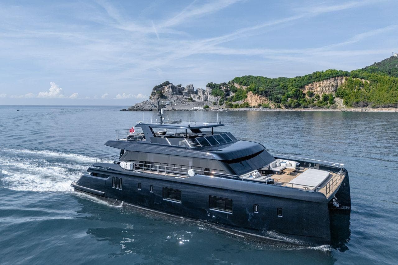 Luxurious 2025 Sunreef 100 Power yacht cruising near scenic coastline.