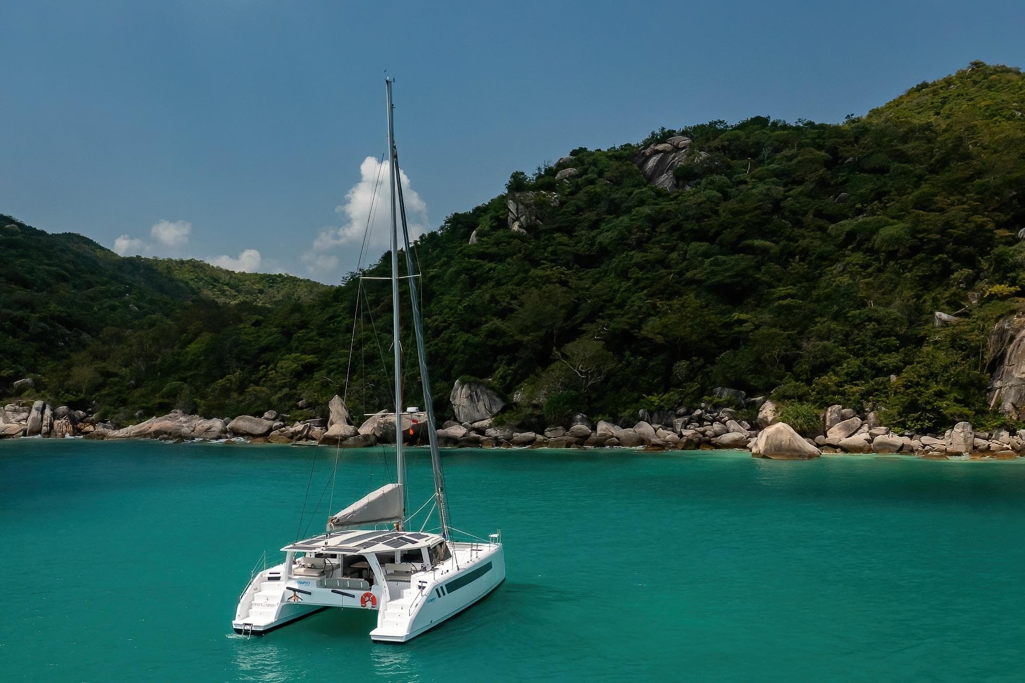 2026 Seawind 1370 catamaran anchored in turquoise bay with lush green hills.