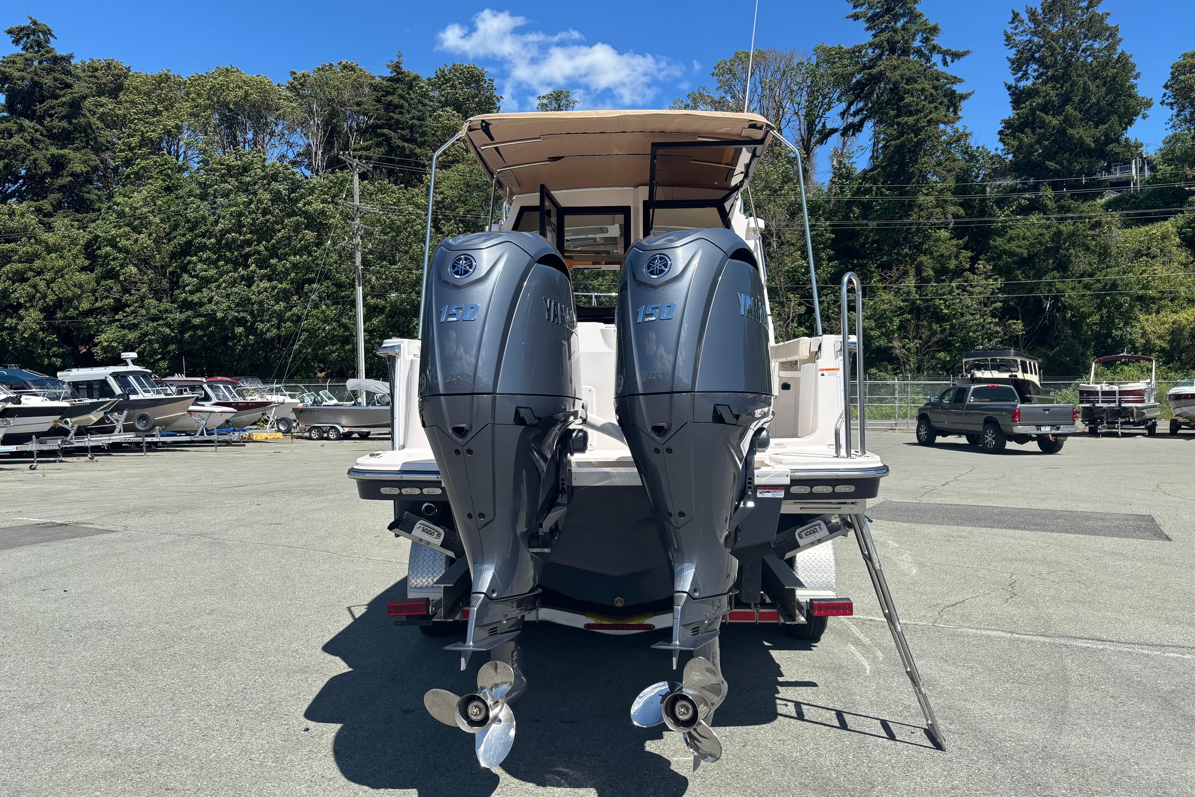 2026 Ranger Tugs R-27 boat with dual Yamaha 150 outboard motors in a marina setting.