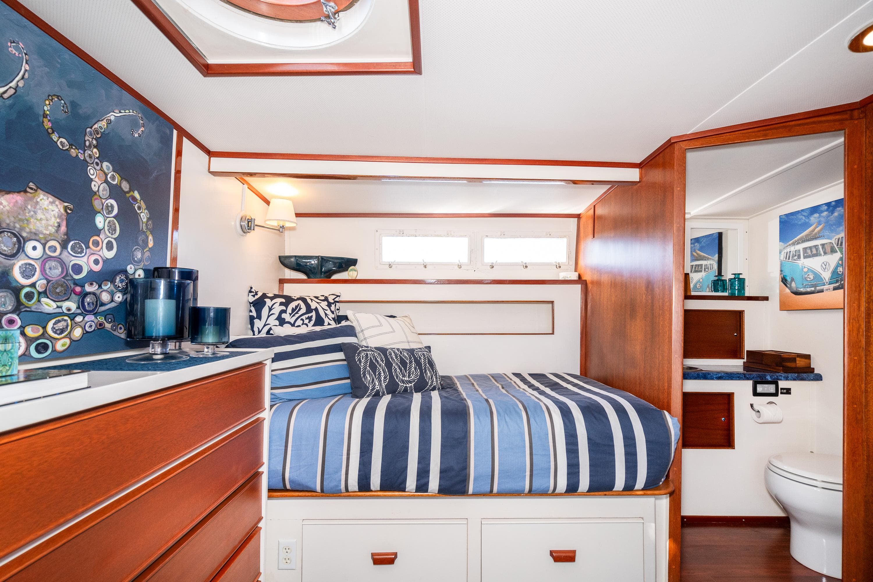 1965 Chris-Craft 57 Constellation cabin with striped bedding and nautical decor.