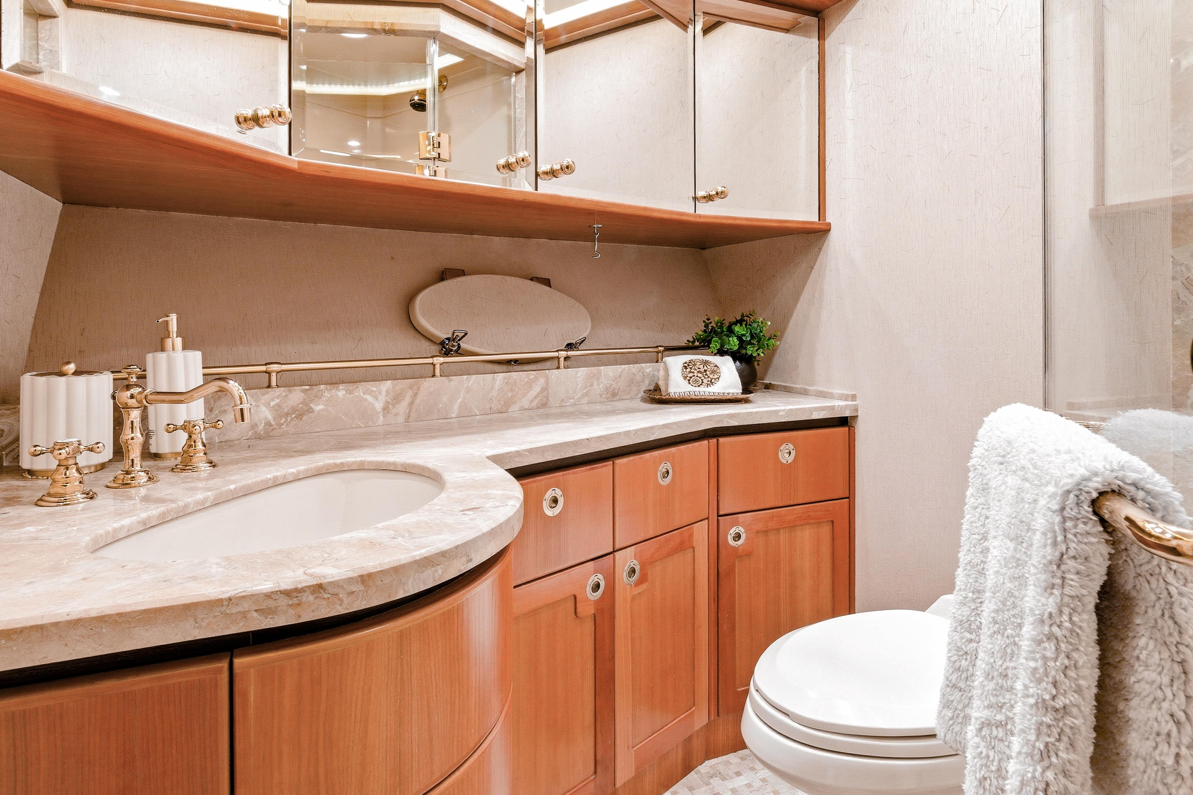 Luxurious bathroom in 2003 West Bay Sonship yacht with elegant fixtures and marble countertop.