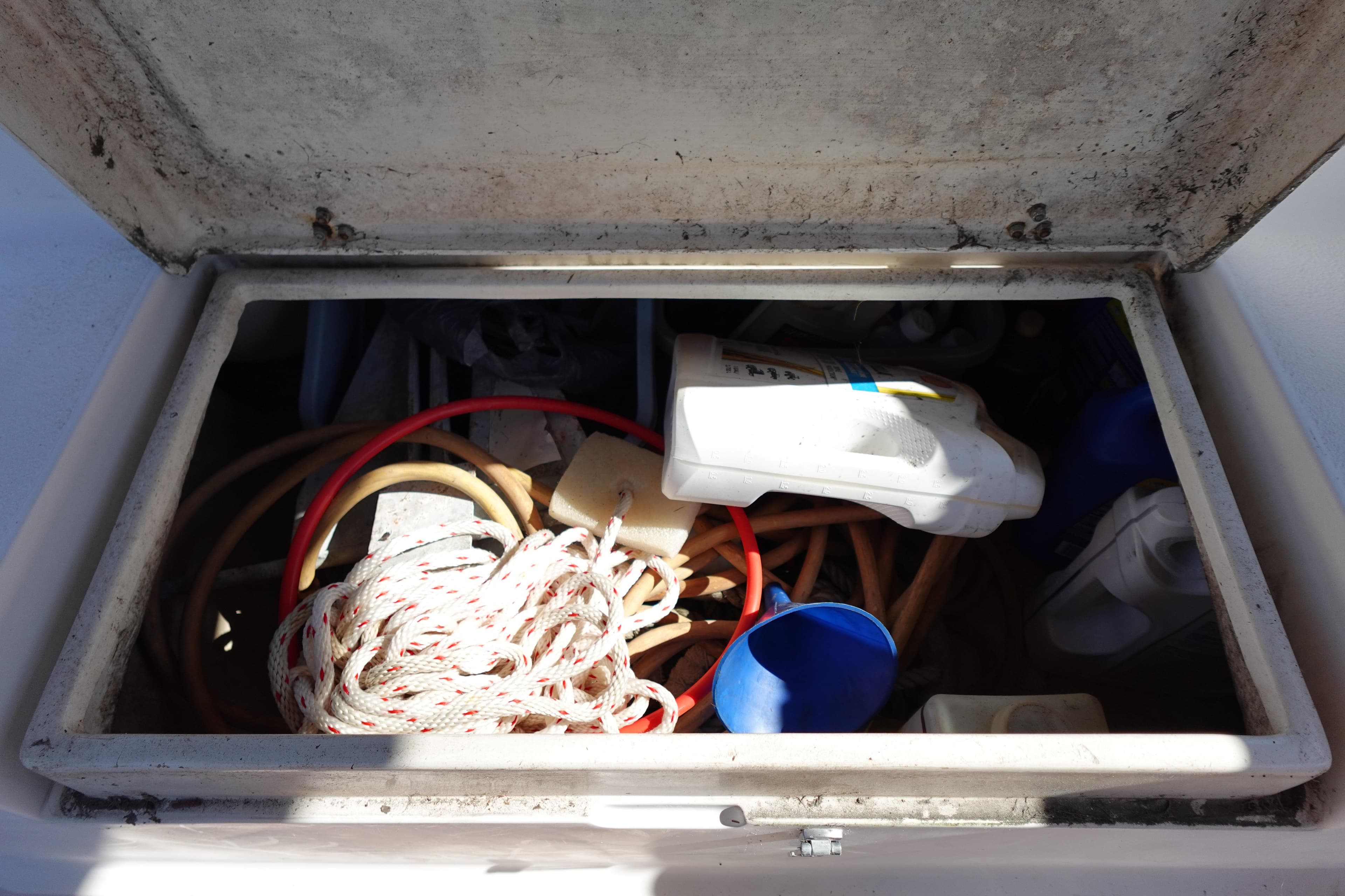 Storage compartment on a 1997 Catalina 28 sailboat with ropes and equipment.