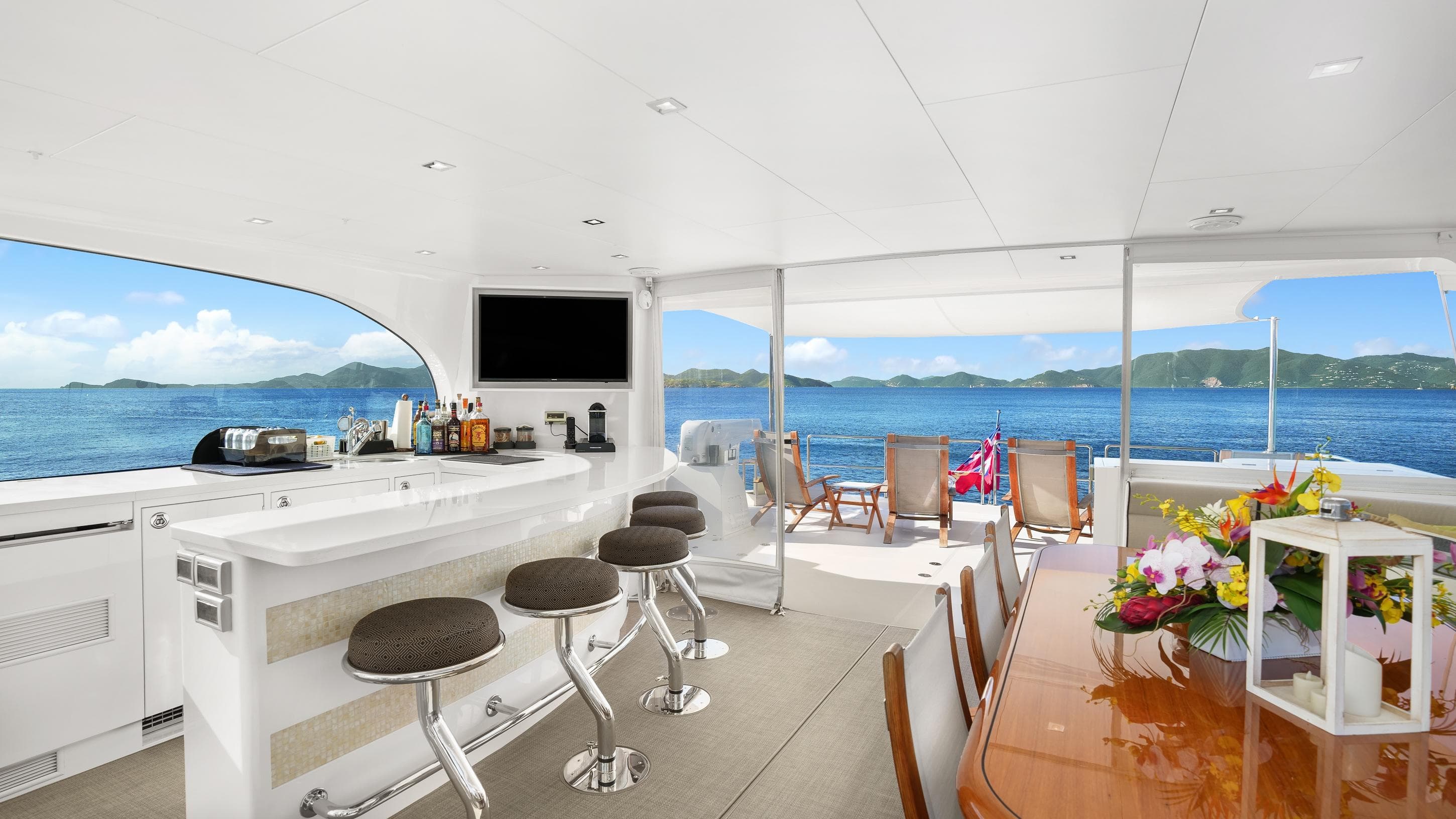 Luxurious Horizon PC74 yacht interior with bar, dining area, and ocean view.