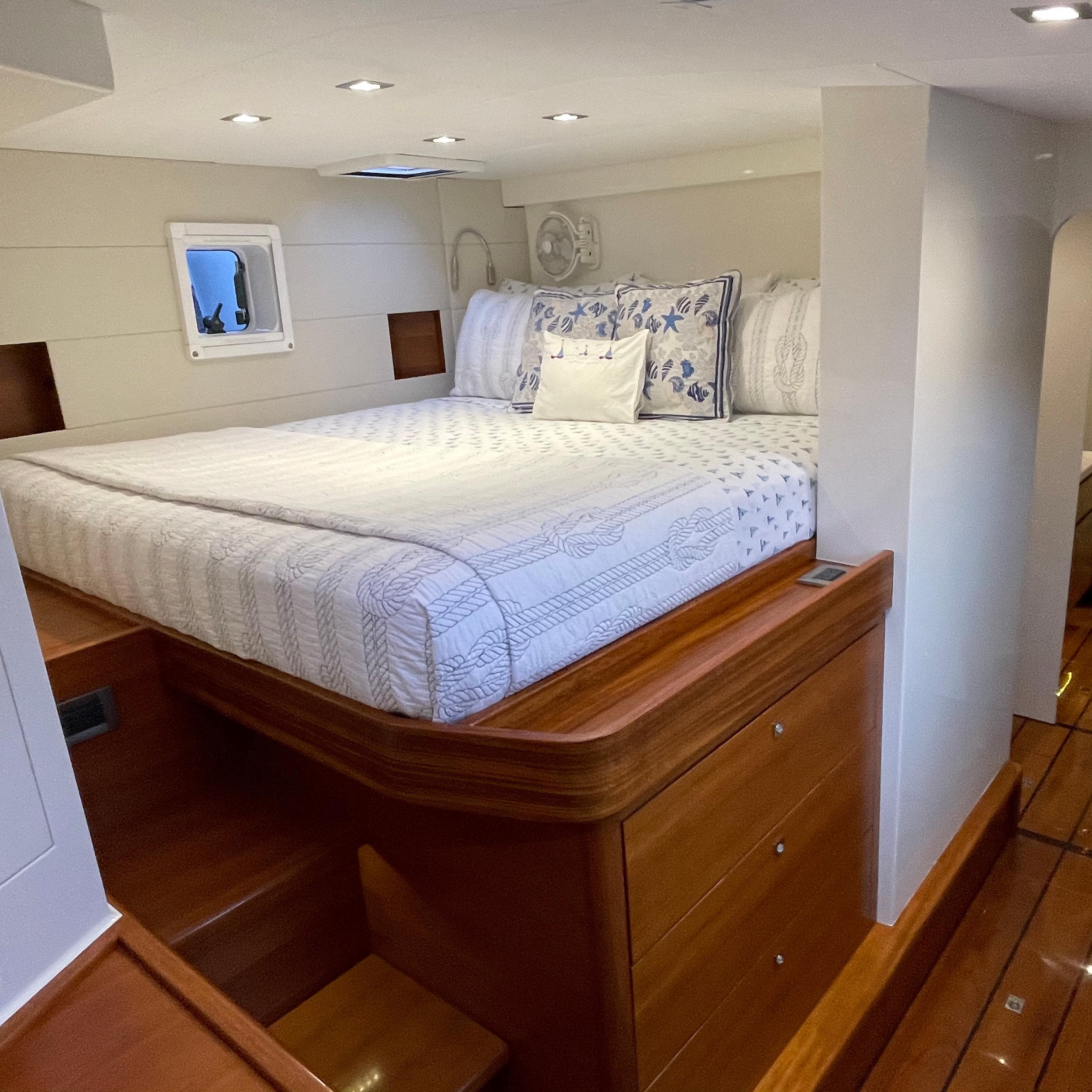 Luxurious bedroom interior of 2015 Gunboat 60 yacht with elegant bedding and wooden accents.