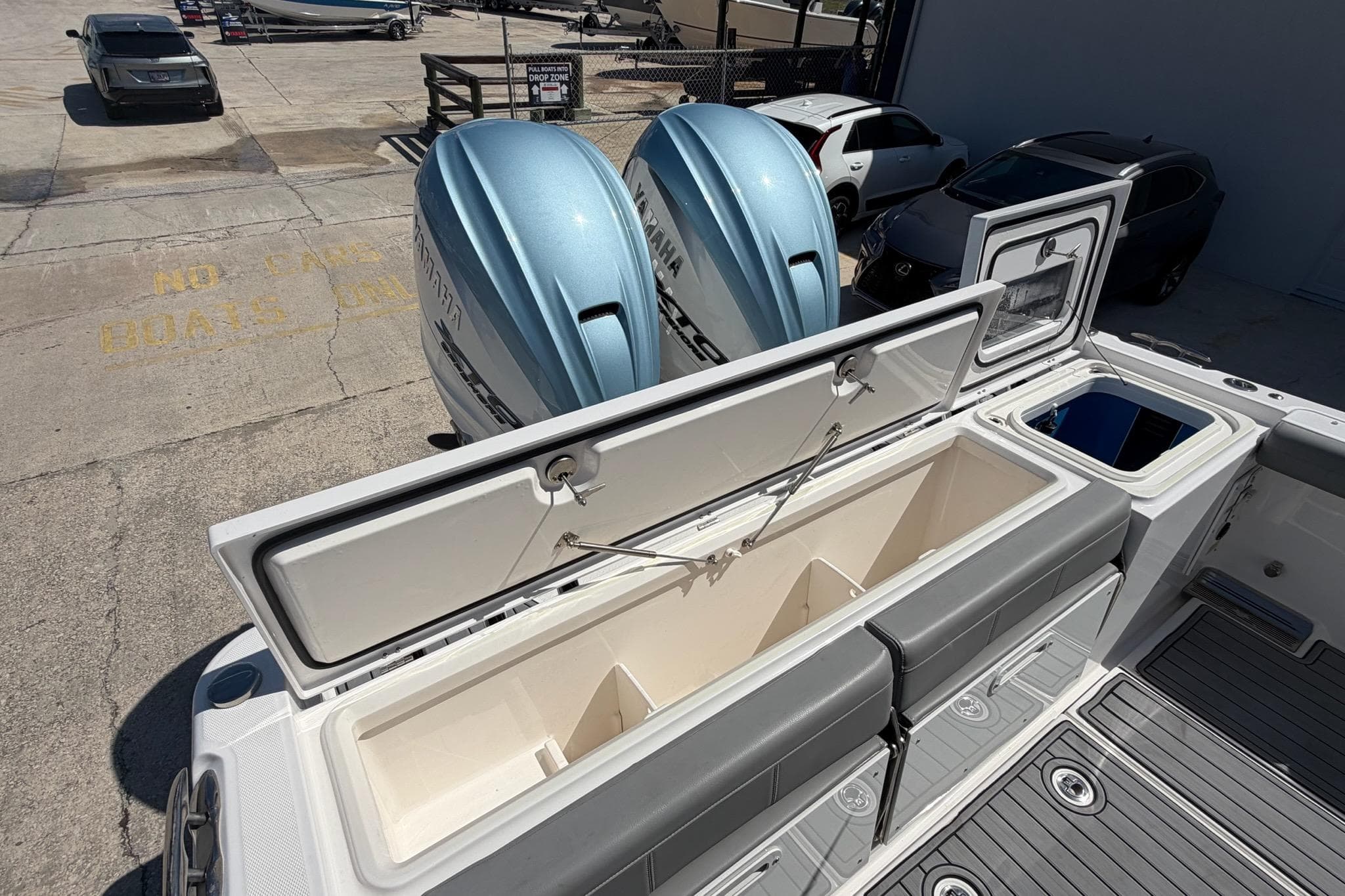 2024 Everglades 335 Center Console boat with open storage compartments and twin outboard engines.