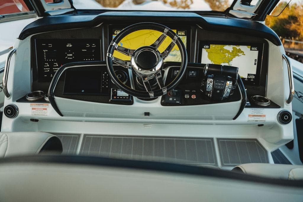 Luxurious 2018 MTI 57 yacht cockpit with advanced navigation displays and sleek steering wheel.