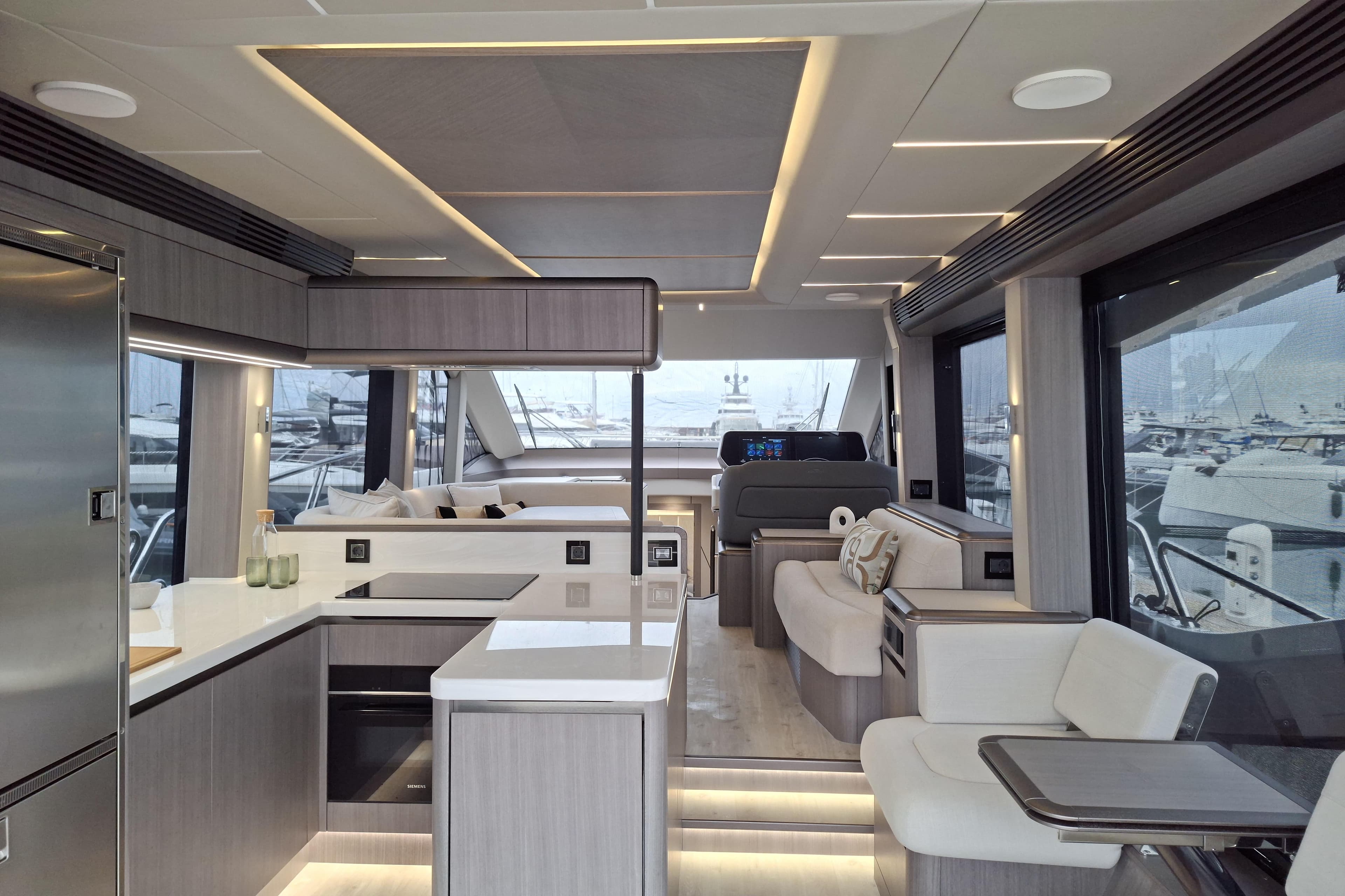 Luxurious interior of 2026 Galeon 560 Fly yacht with modern kitchen and seating area.