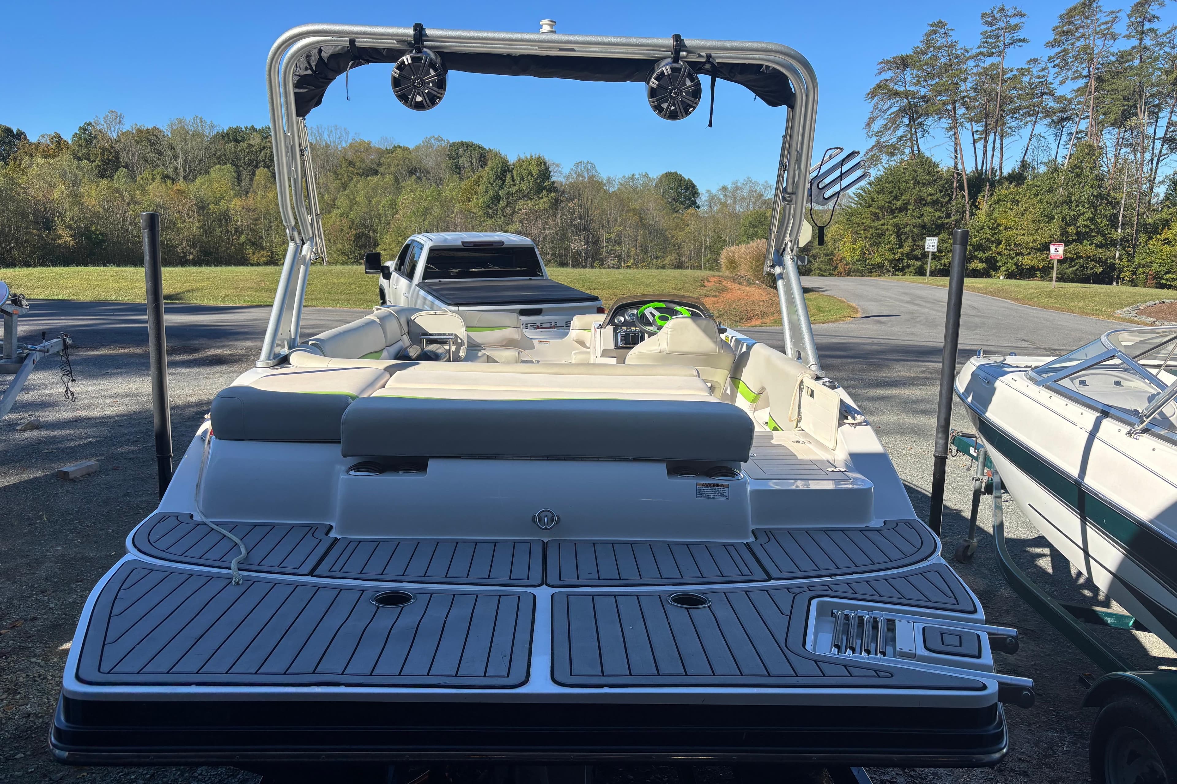 2018 Starcraft Star Step 221 I/O boat with sleek deck and seating, parked outdoors.