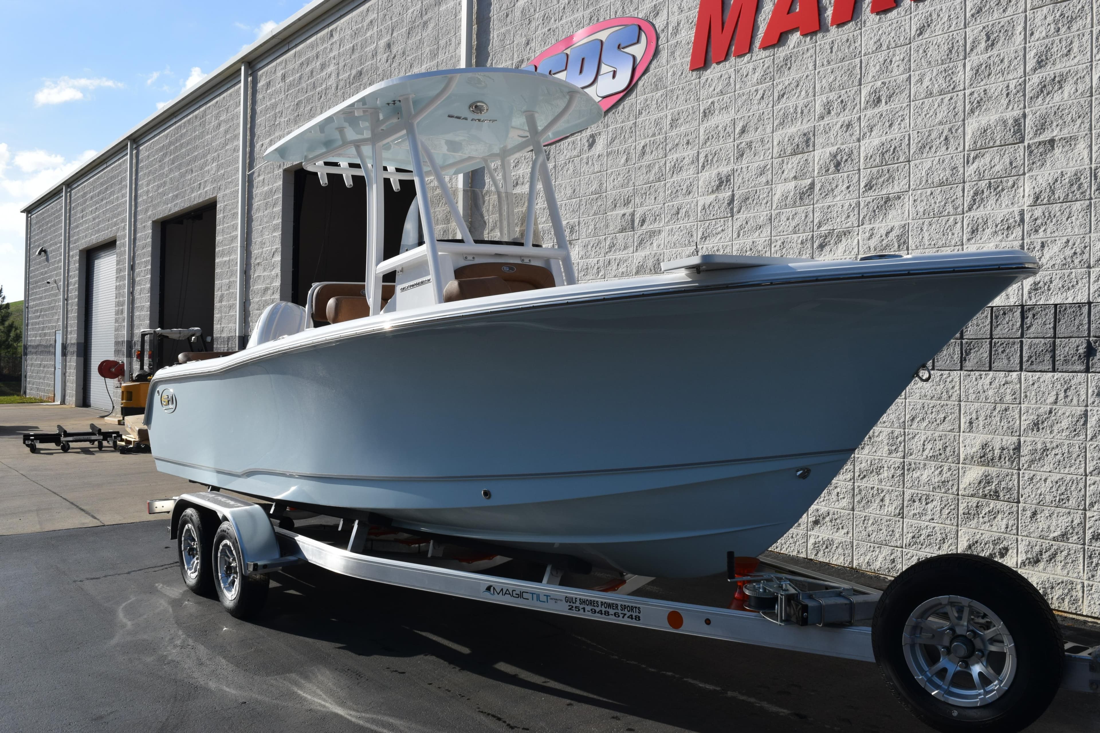 2026 Sea Hunt Ultra 229 boat on trailer outside a marine dealership.