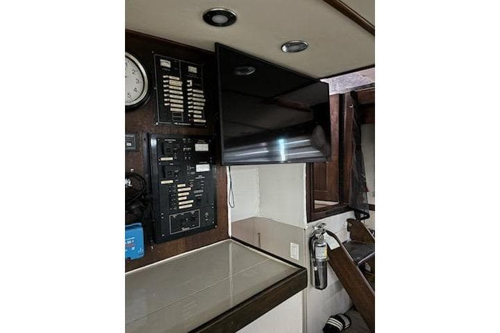 Interior of 1967 Hatteras 44 Tri Cabin with control panels and mounted TV.