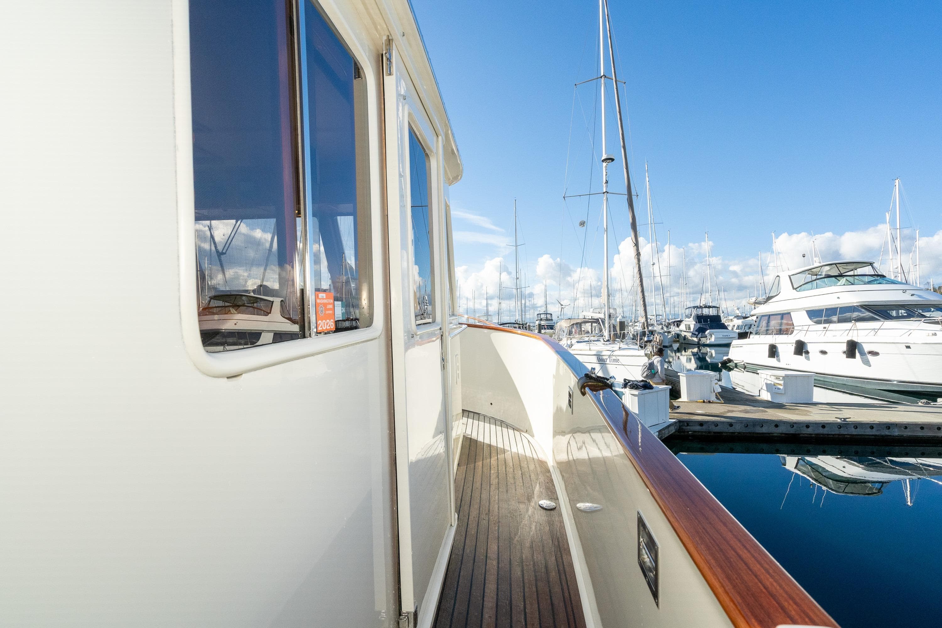 2001 Fleming 55 Pilothouse yacht docked at marina under clear blue sky.