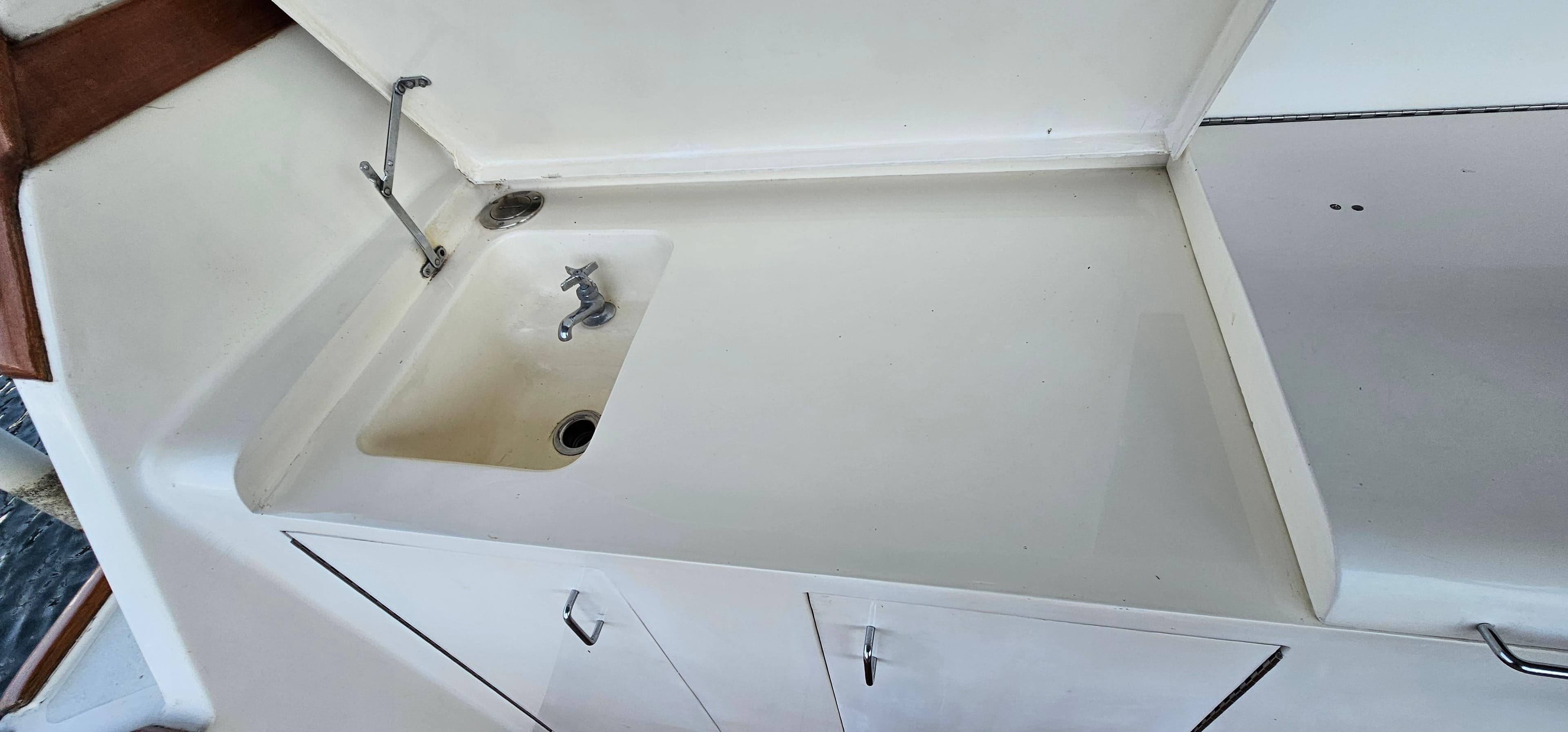 1987 Ocean Yachts 48 Super Sport sink area with white cabinetry and faucet.