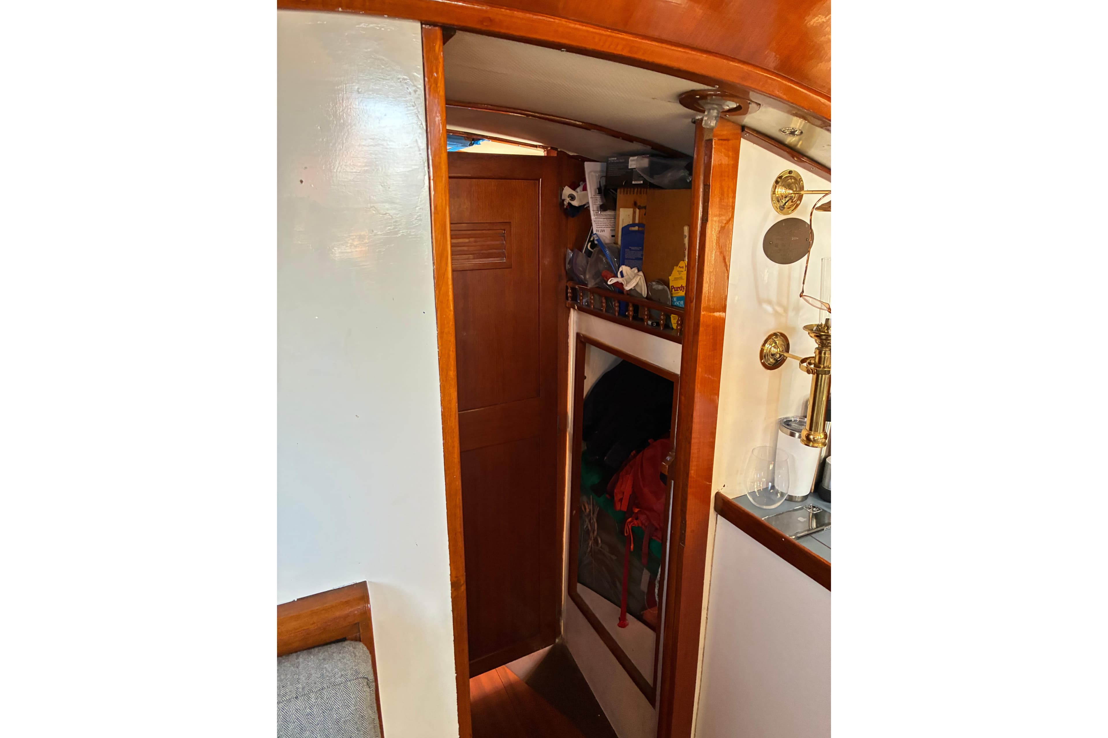 Interior of 1974 Cheoy Lee Luders Offshore 28 sailboat, featuring wooden cabinetry and brass fixtures.