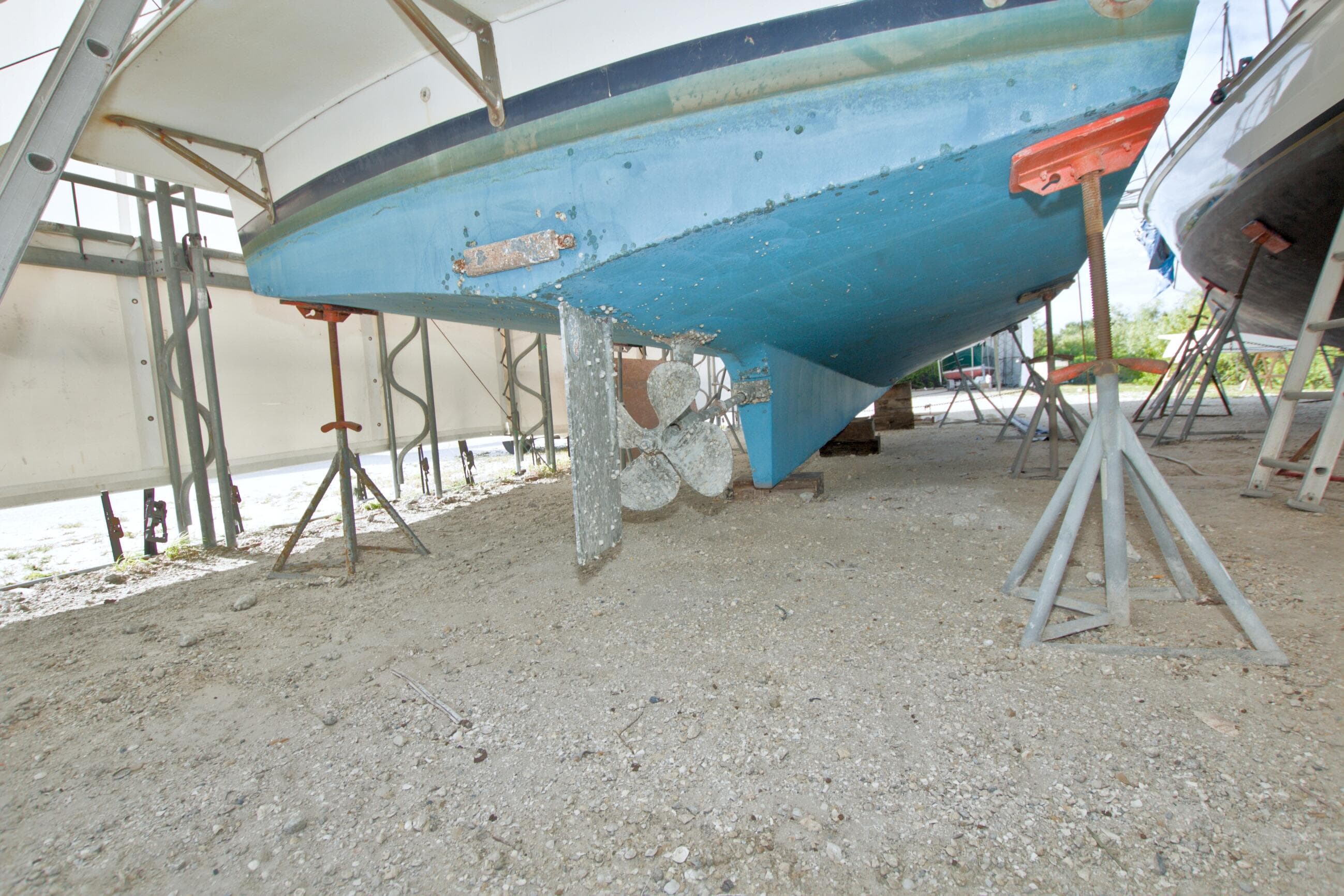 1999 Monk 36 Trawler on stands, showing blue hull and propeller.