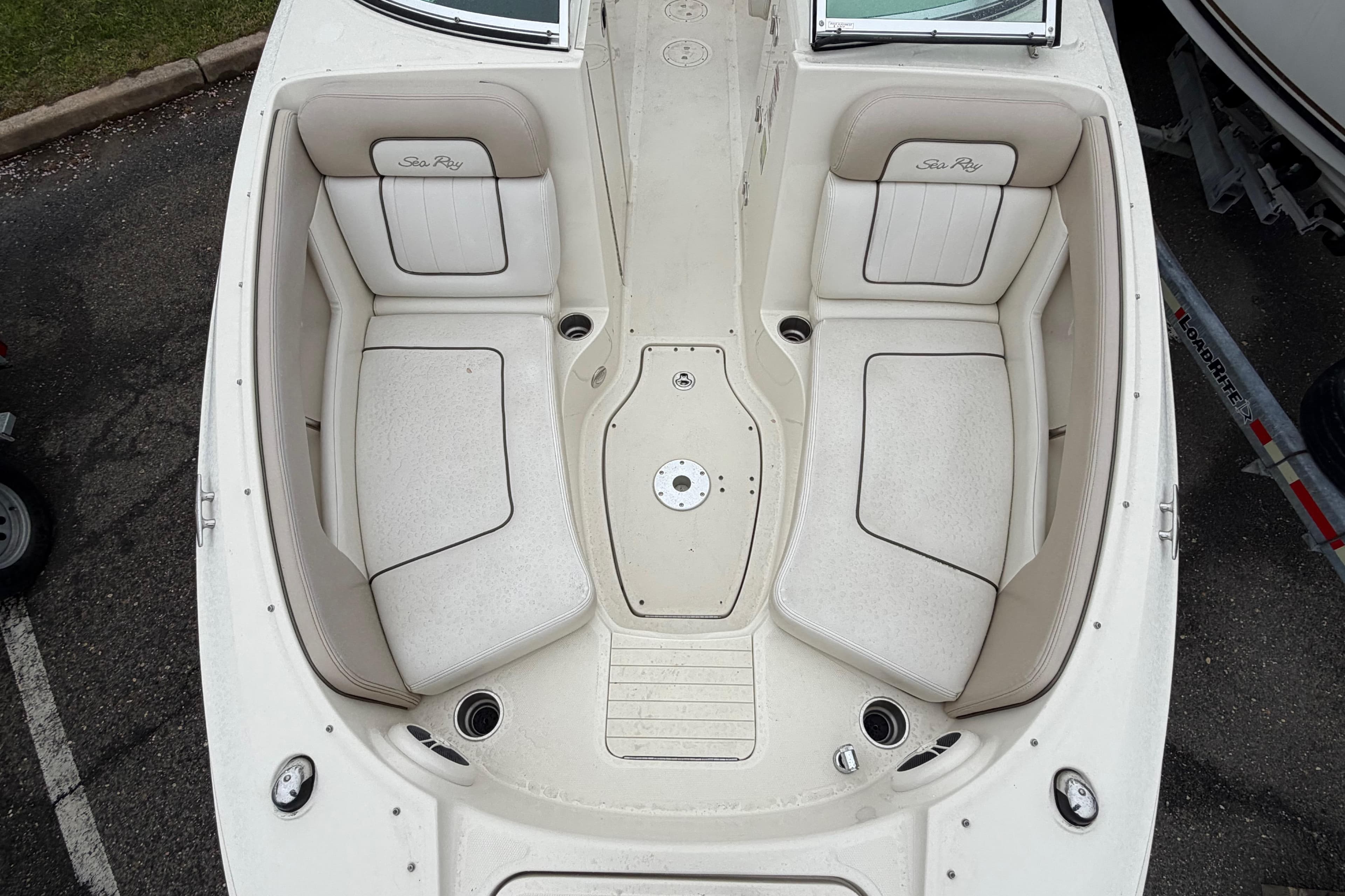 2009 Sea Ray 210 Sundeck boat interior with white seating and cup holders.