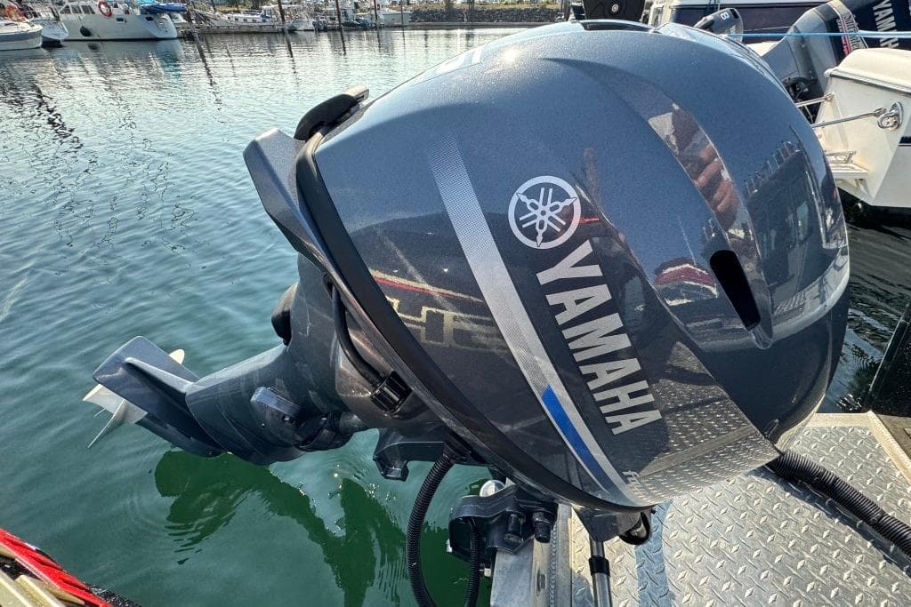 Outboard motor on a 2023 Boulton VOYAGER PRO boat at a marina.