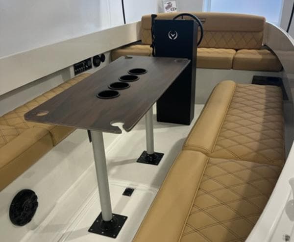 2024 Vision Marine Technologies Fantail 217 interior with tan seating and a central table.