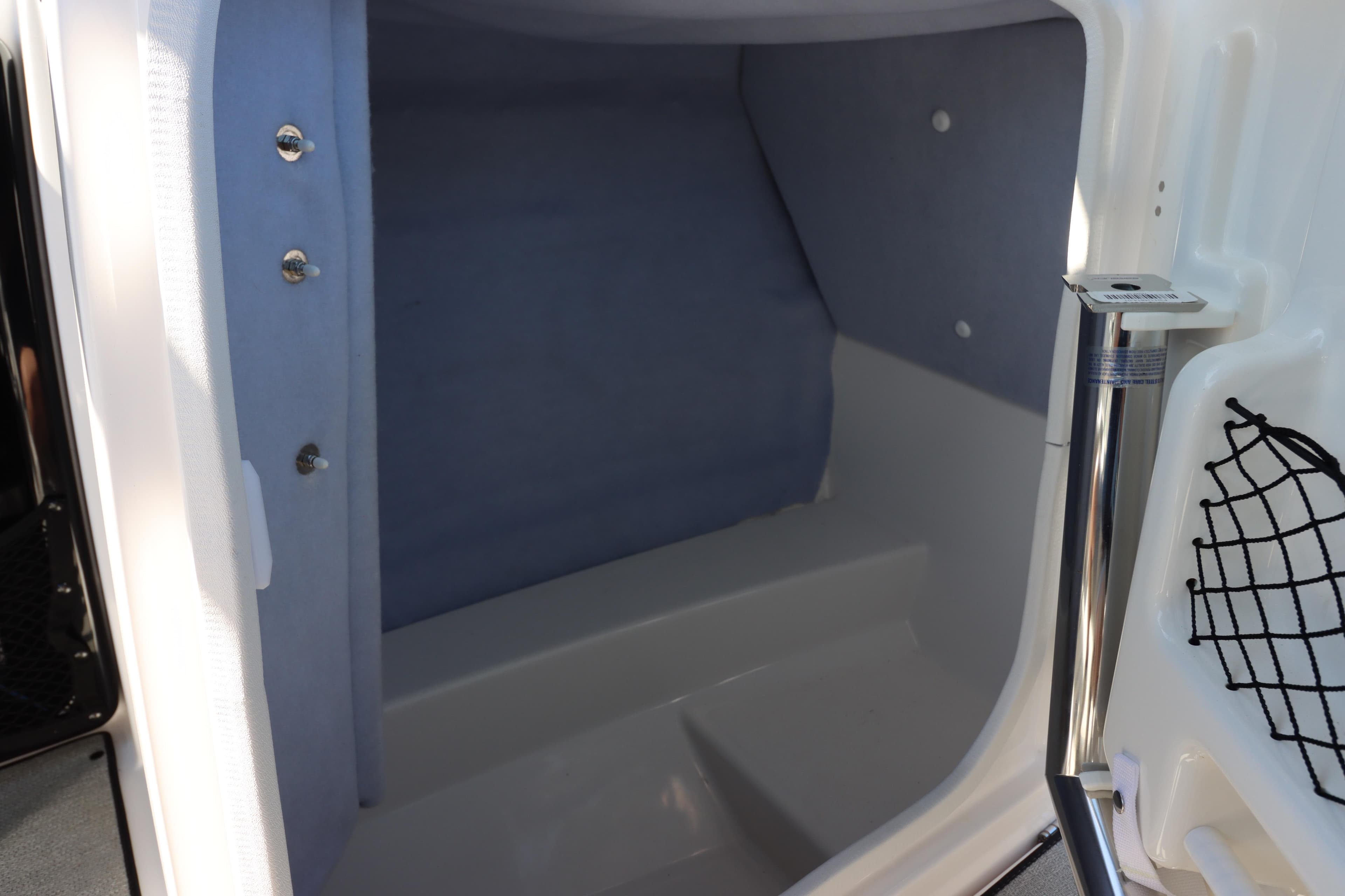 Interior storage compartment of 2023 Yamaha AR250 boat, featuring sleek design and practical netting.