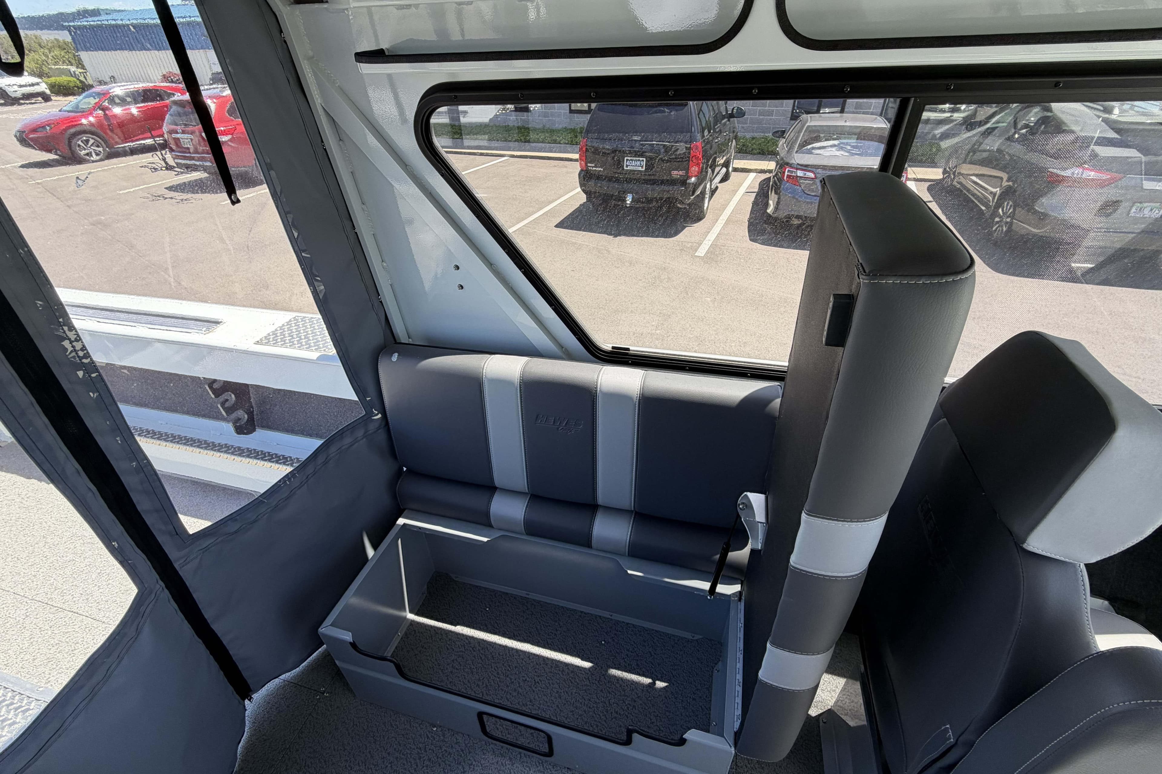 Interior view of 2026 Hewescraft 240 Ocean Pro ET Hardtop boat with seating and storage.