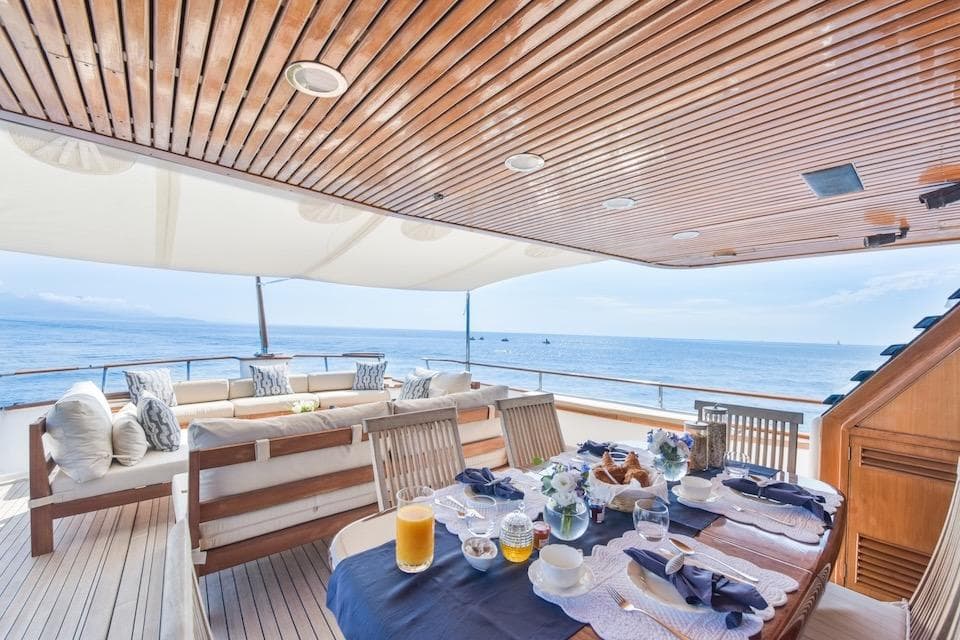 Luxurious yacht deck with dining setup, ocean view; W.A. Souter & Sons 34, 1984 model.