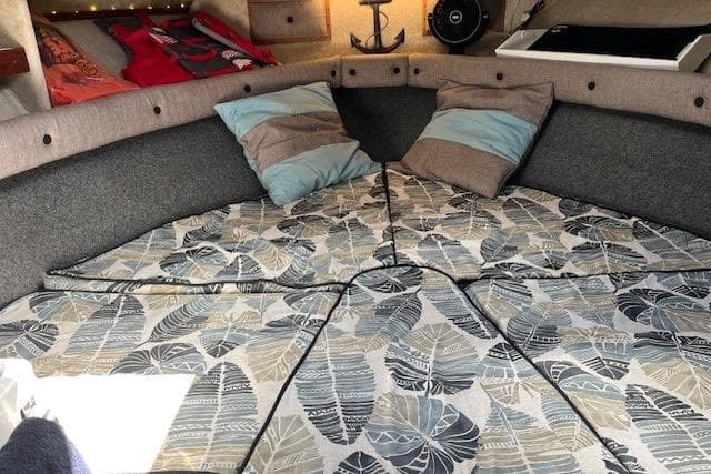 1988 Penn Yan Predator 288 cabin interior with patterned bedding and decorative pillows.