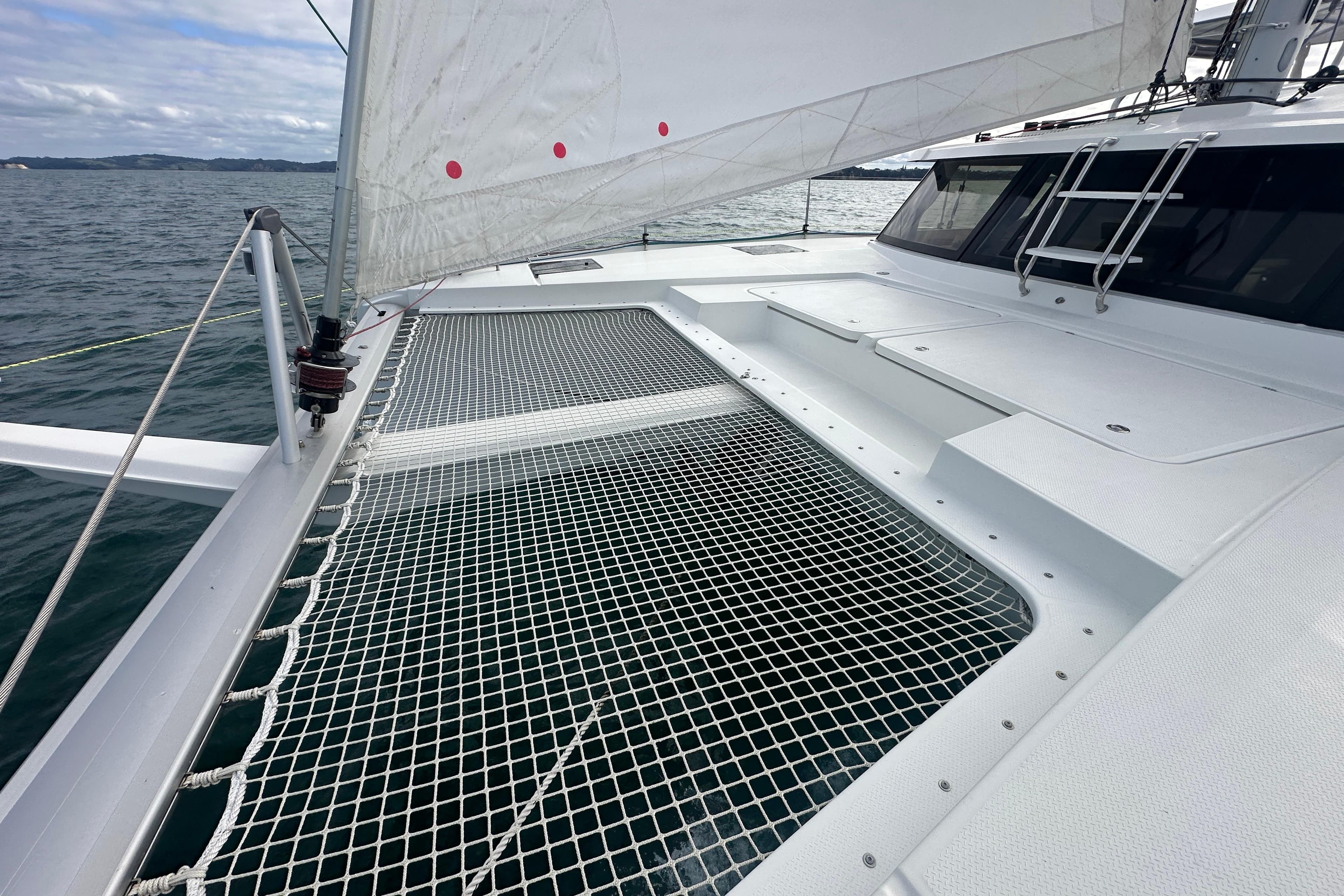 2019 Fountaine Pajot Astrea 42 Catamaran sailing on open water, featuring netted deck area.
