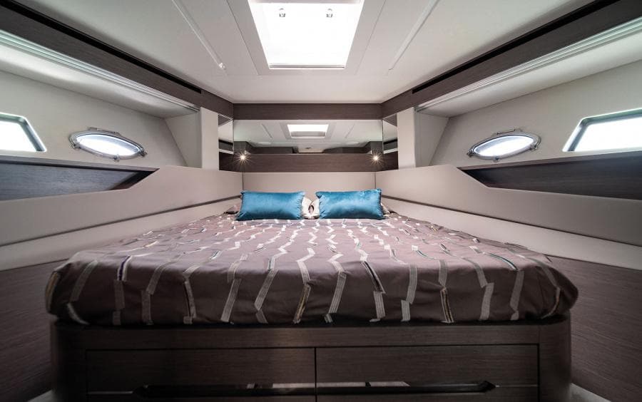 Luxurious bedroom interior of 2024 Pershing 8X yacht with modern design and skylight.