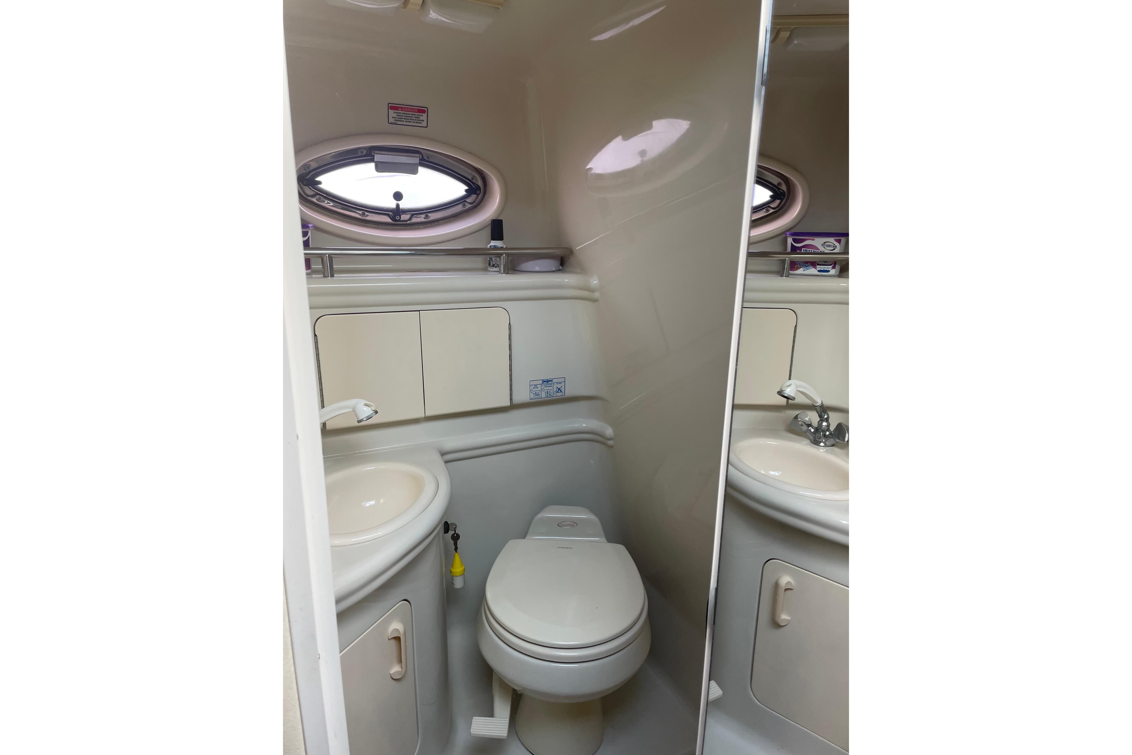 2006 Sea Ray Sundancer 280 bathroom with sink, toilet, and porthole window.